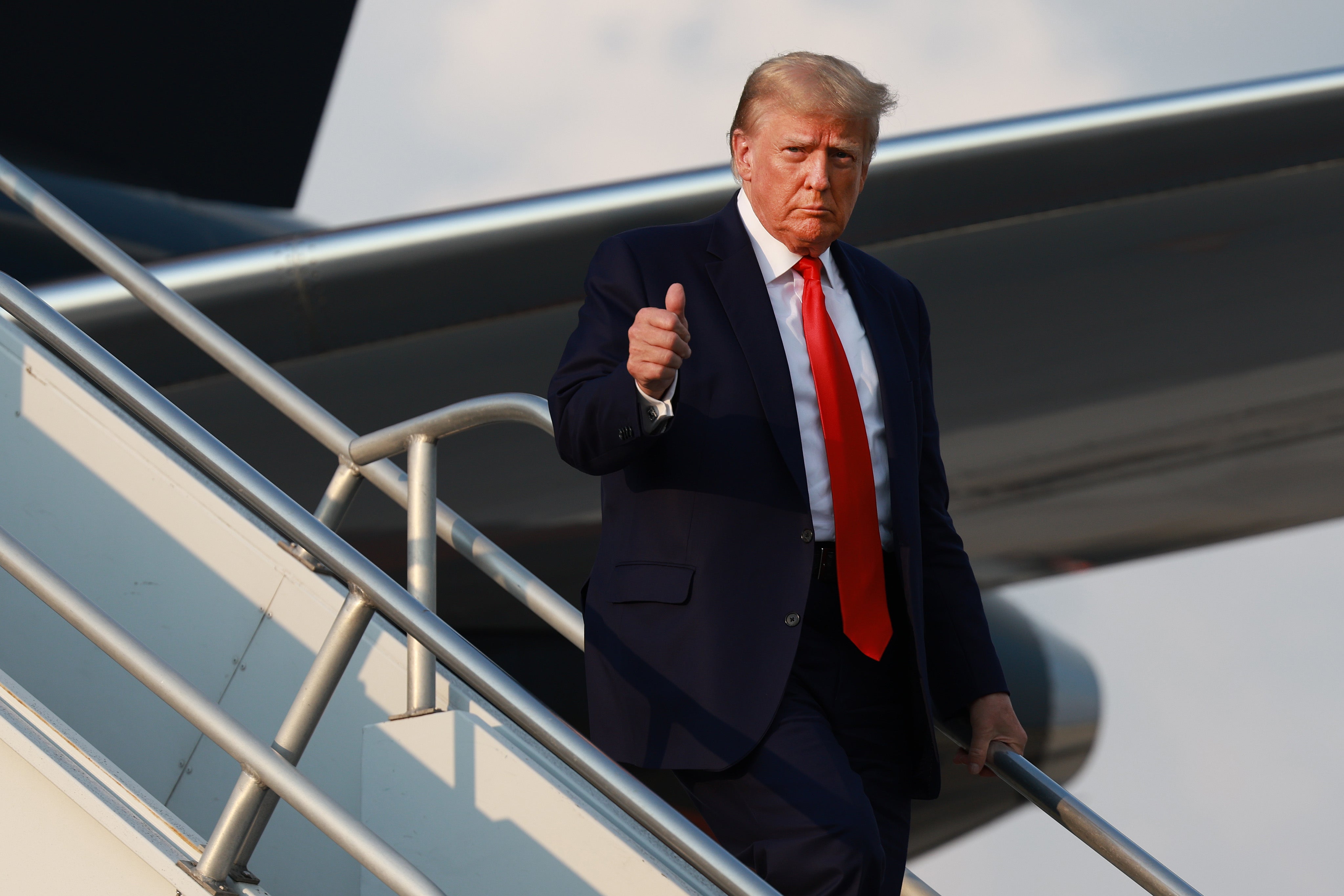 Former U.S. President Donald Trump gives a thumbs up as he arrives at Atlanta Hartsfield-Jackson International Airport on August 24, 2023 in Atlanta, Georgia.