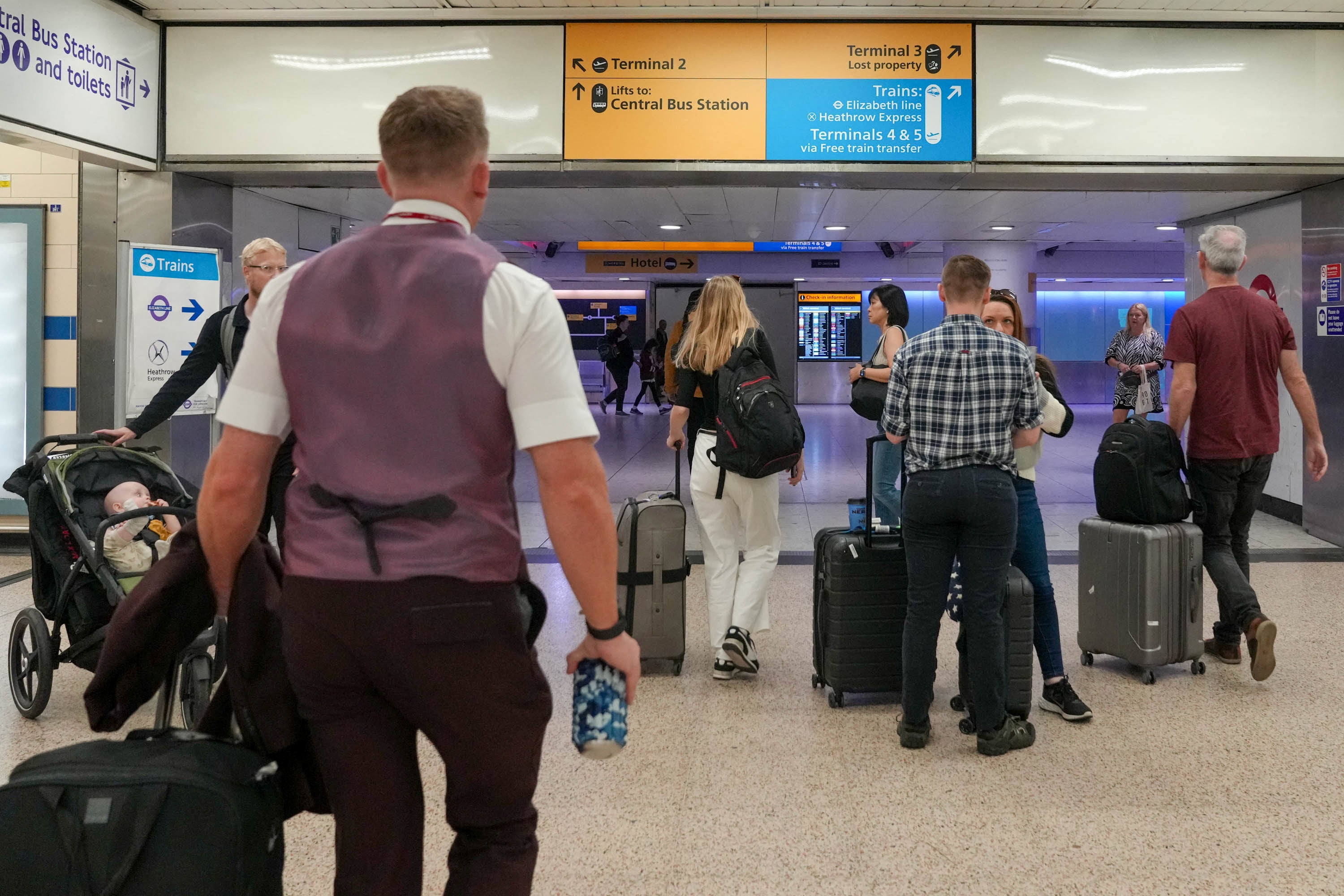 Passengers walk with their luggage to Heathrow Terminal 3 in London