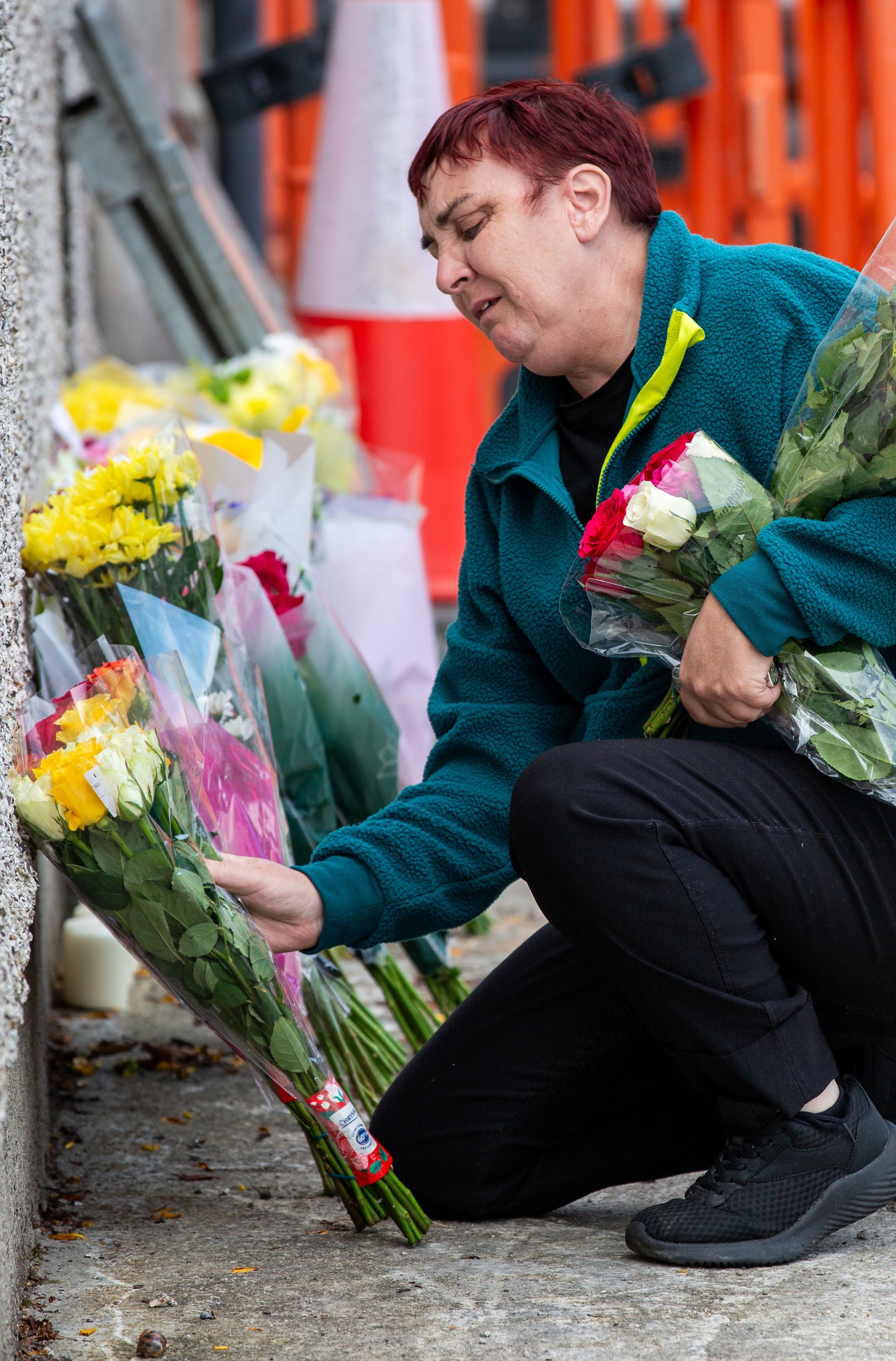 A woman leaves flowers near to the scene of a fatal crash which claimed the four lives