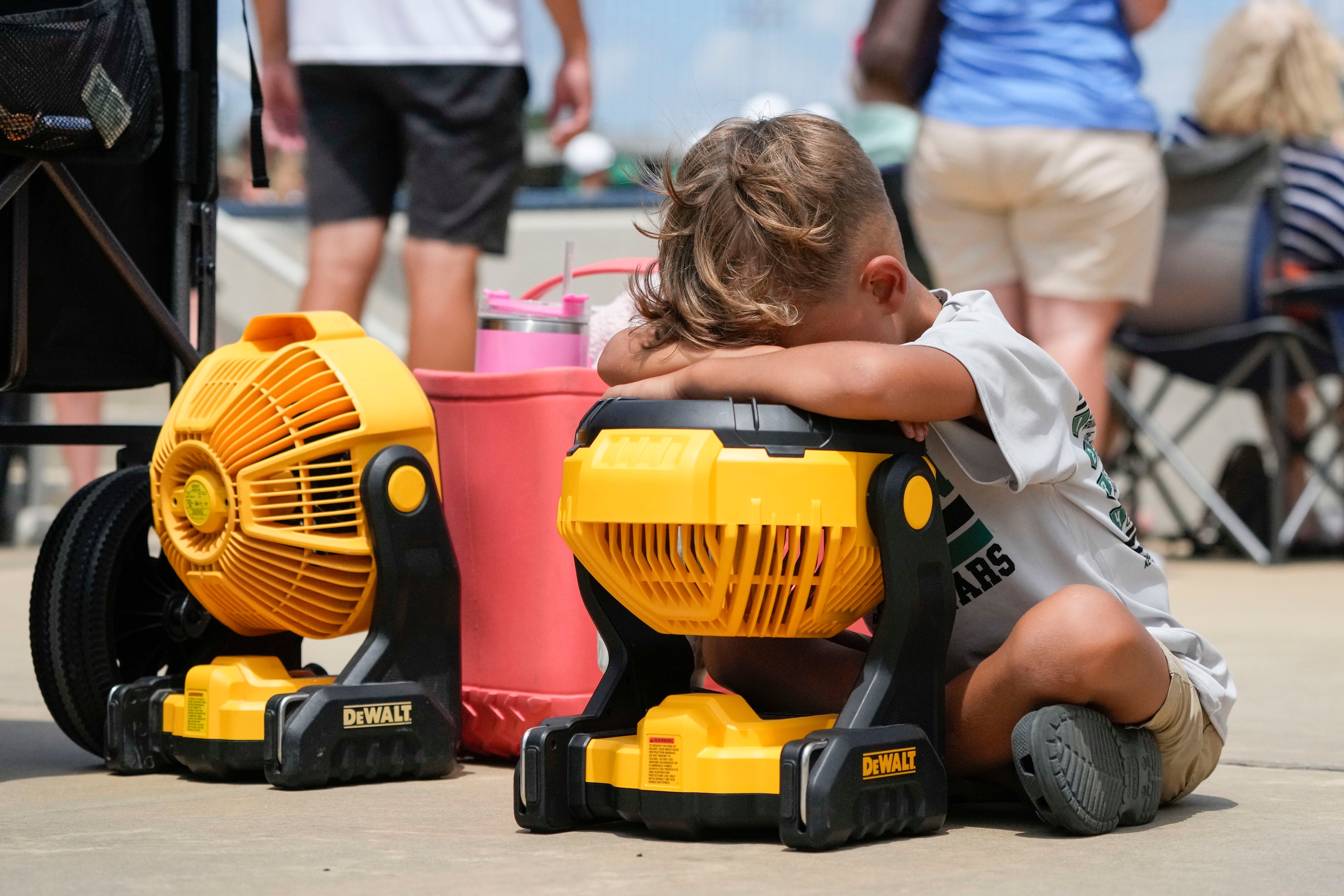 Braxton Hicks, seven, of Livingston, Texas, holds his face to a portable fan to cool off during a Little League tournament in Ruston, Louisiana on August 9. Summer 2023 has brought relentless 100-degree temperatures across large parts of the US south