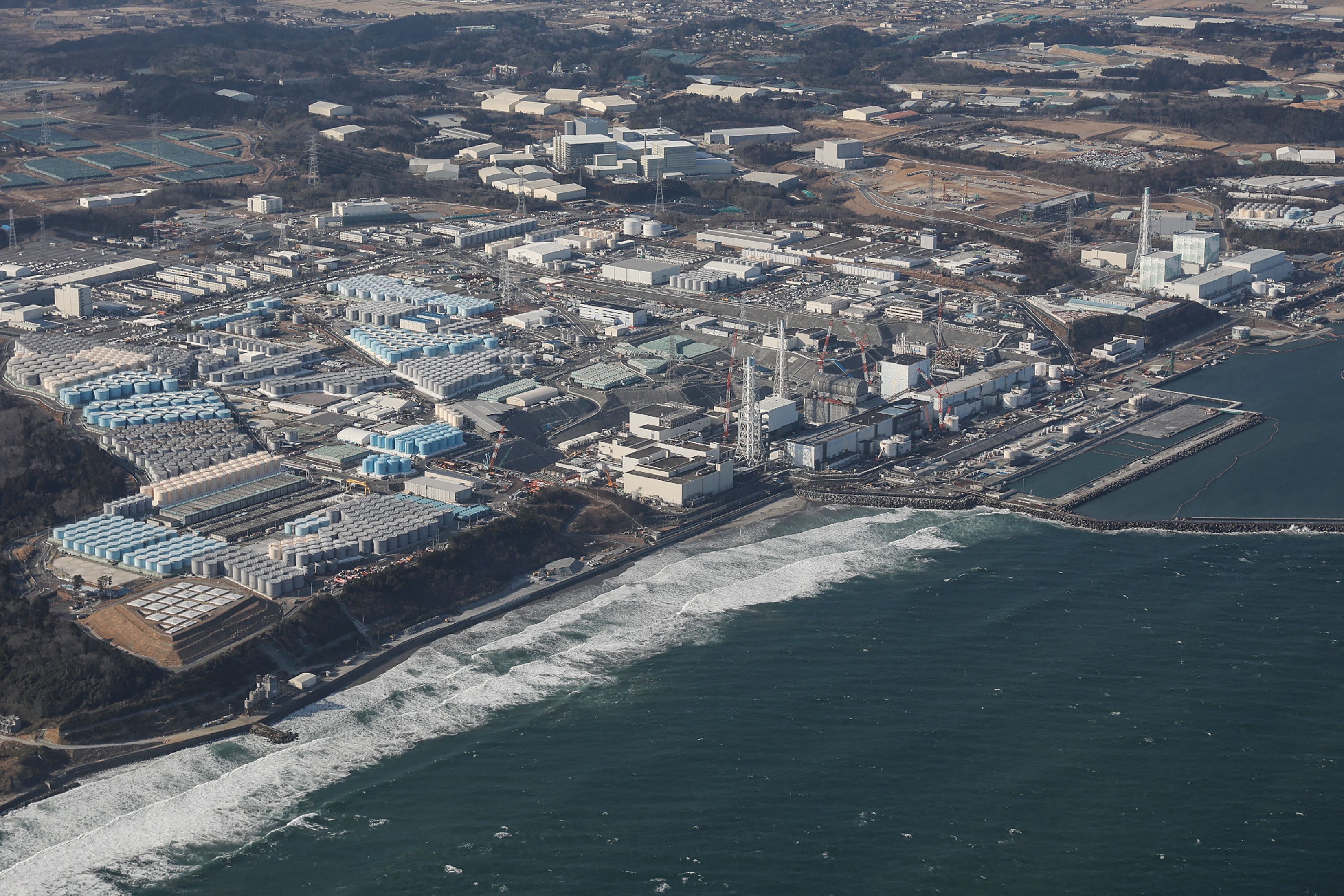 A view of Tepco’s crippled Fukushima Daiichi Nuclear Power Plant as well as tanks (L) used for storing treated wastewater, along the coast in Okuma, Fukushima prefecture