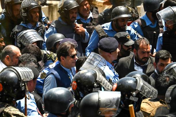 Policemen escort Pakistan’s former prime minister Imran Khan as he arrives at the high court in Islamabad on 12 May 2023