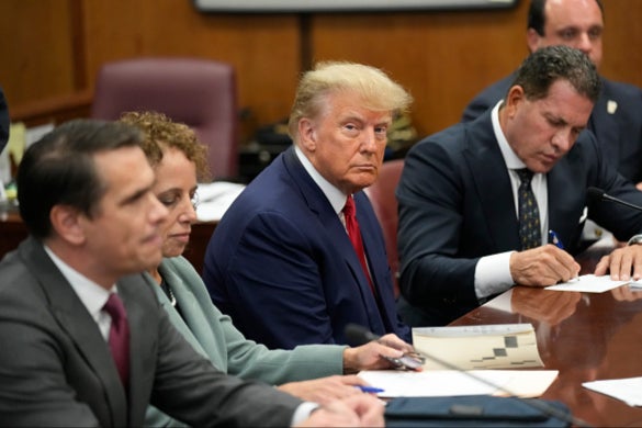 Former US President Donald Trump sits at the defense table with his defense team in a Manhattan court during his arraignment on April 4, 2023, in New York City