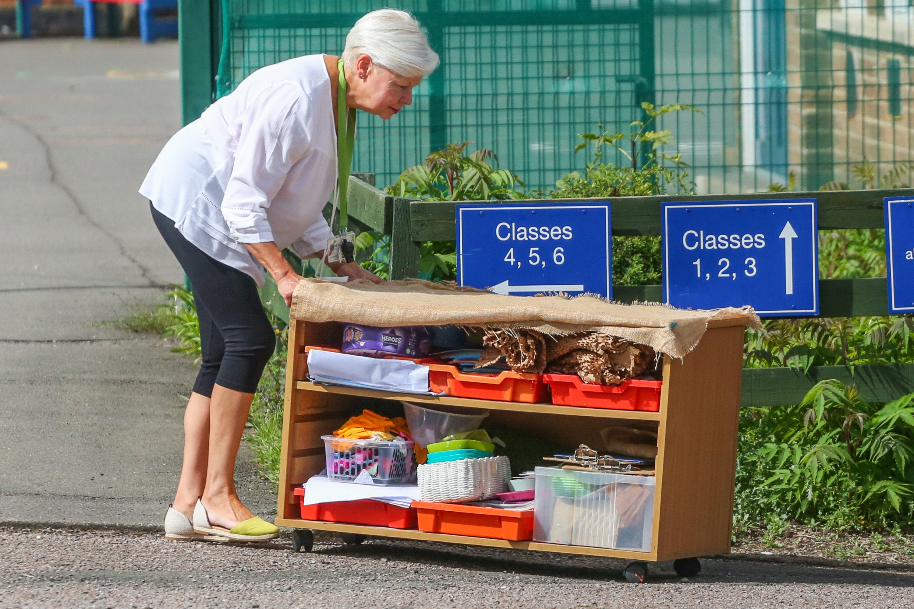 Staff move furntiure and equipment to a new venue after the school was shut by the government on Thursday