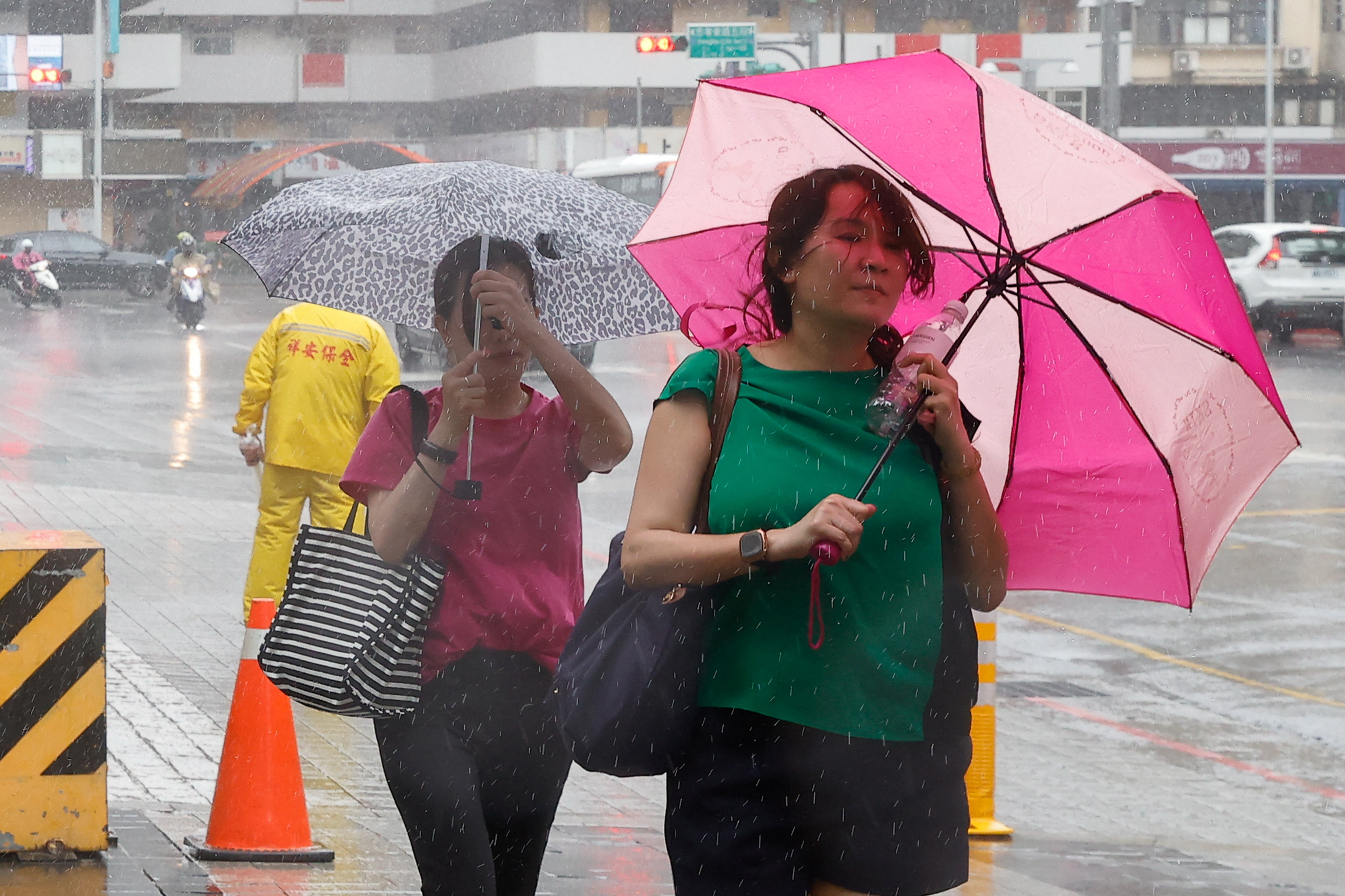 People walk with umbrellas in Taipei as Typhoon Haikui approaches