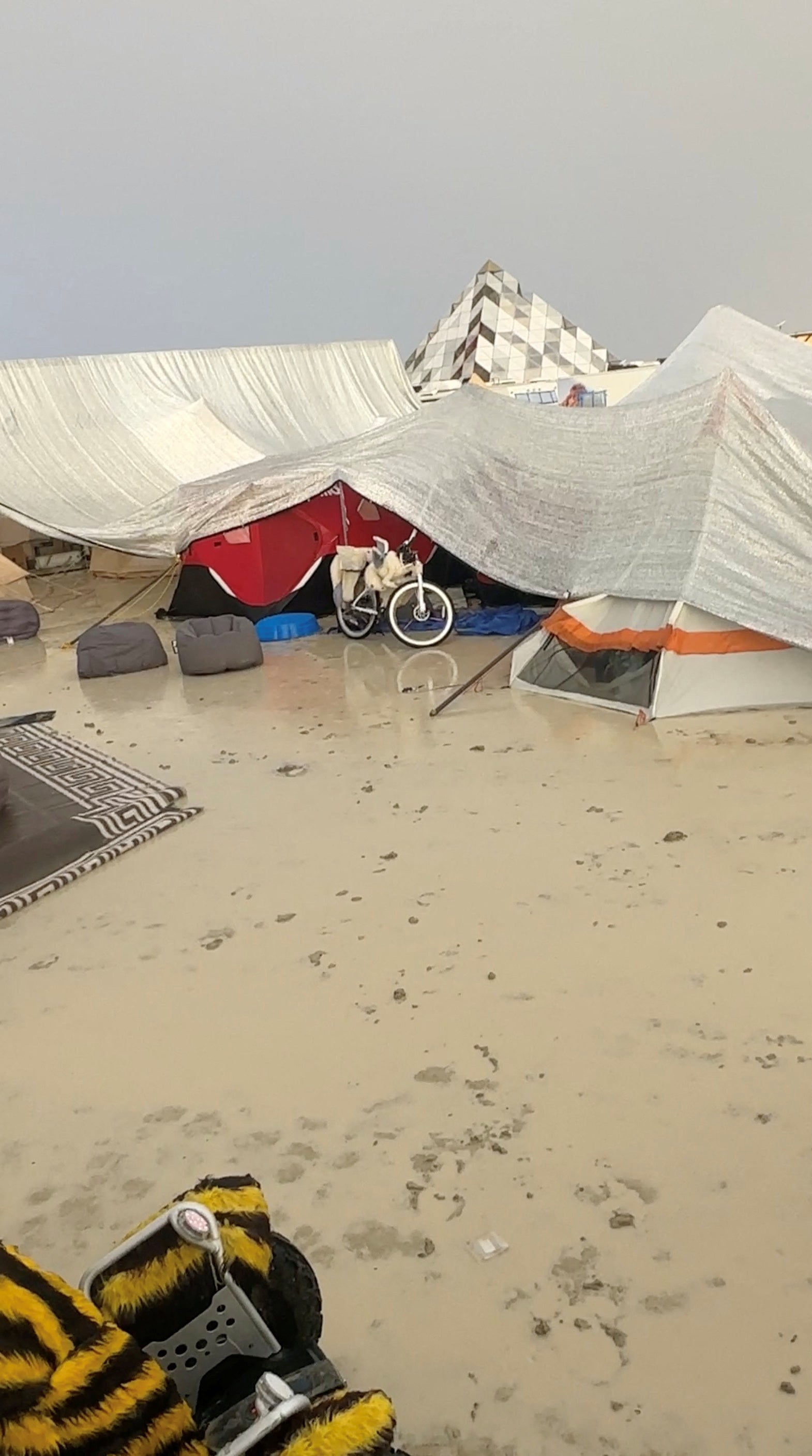 Tents are seen covered to protect them from the rain at Burning Man