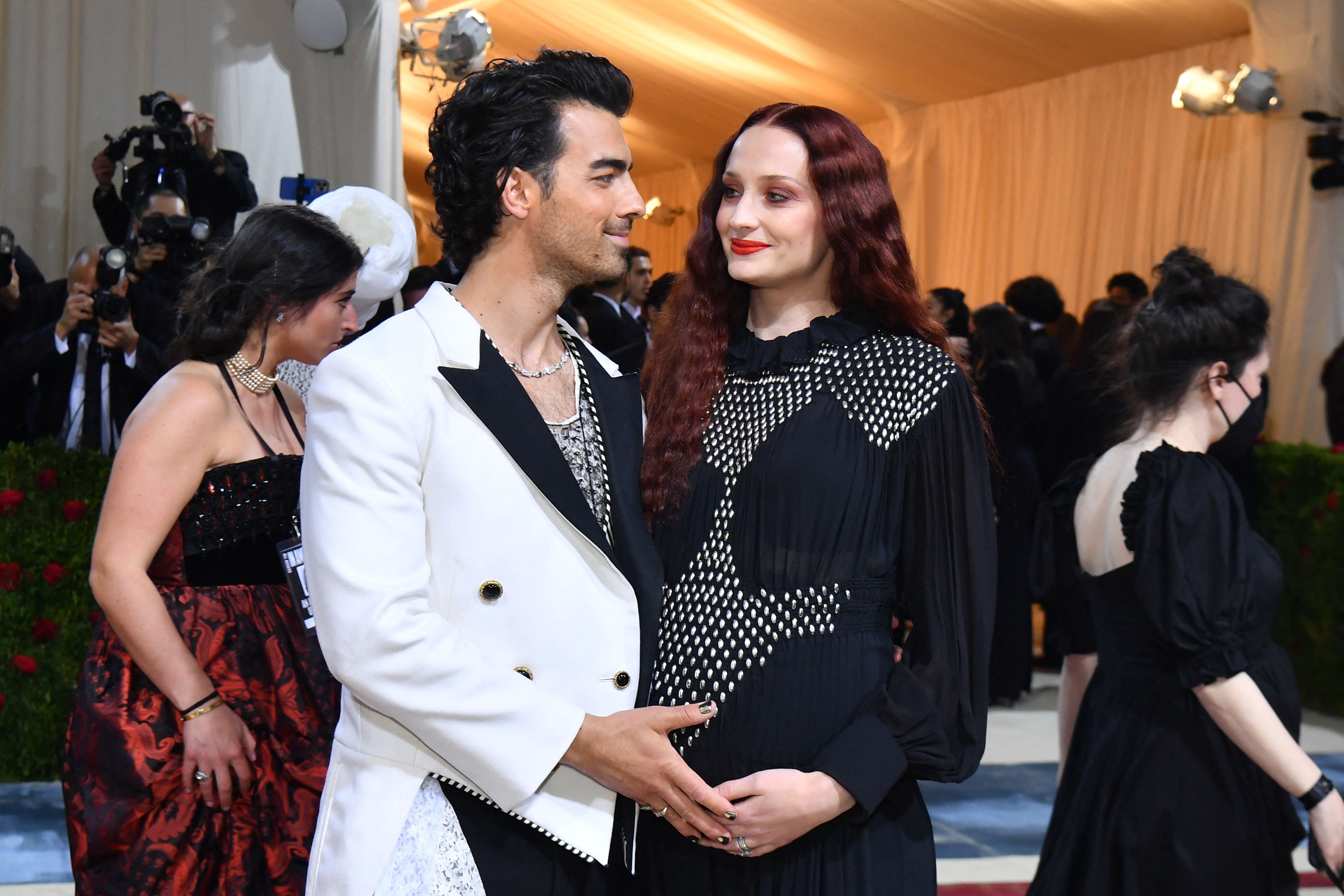 Pair cradle baby bump at Met Gala