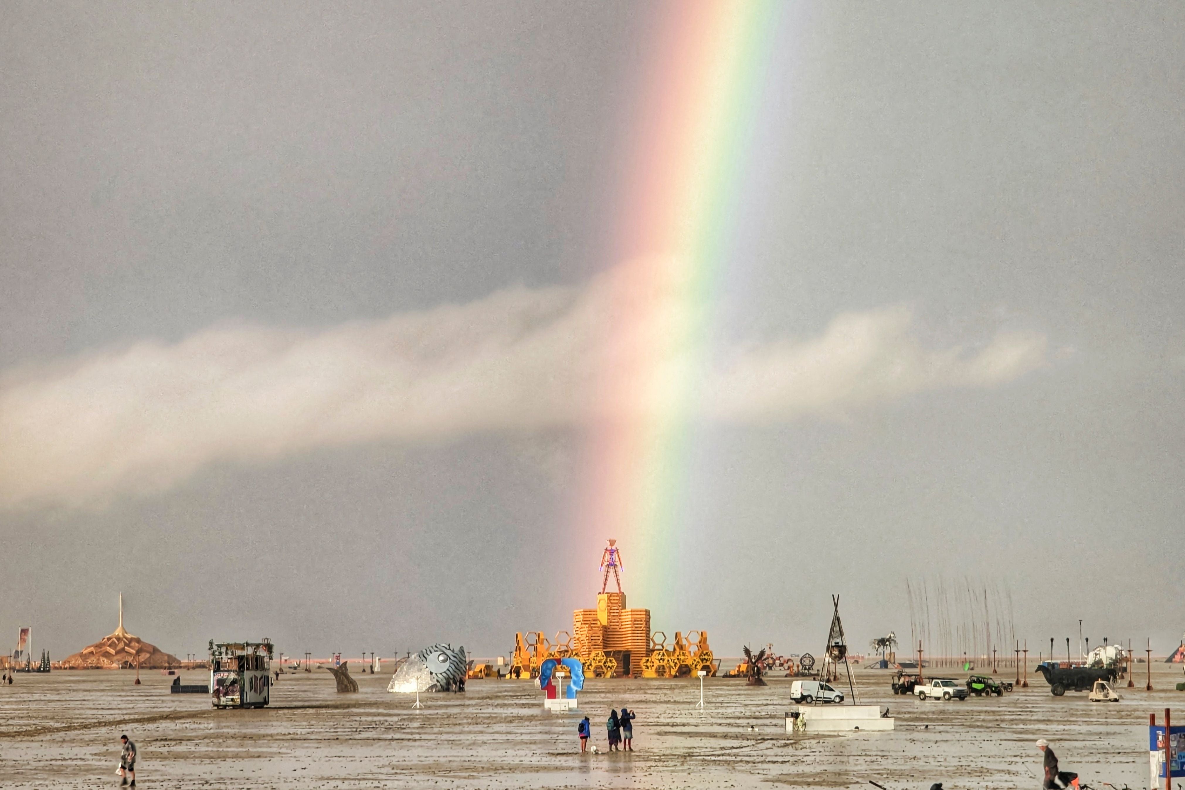 A rainbow over flooding on a desert plain