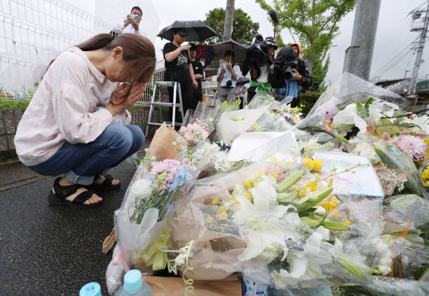 This 19 July 2019 picture shows a resident praying for victims of a fire which hit the Kyoto Animation studio building the day before, killing 33 people, in Kyoto