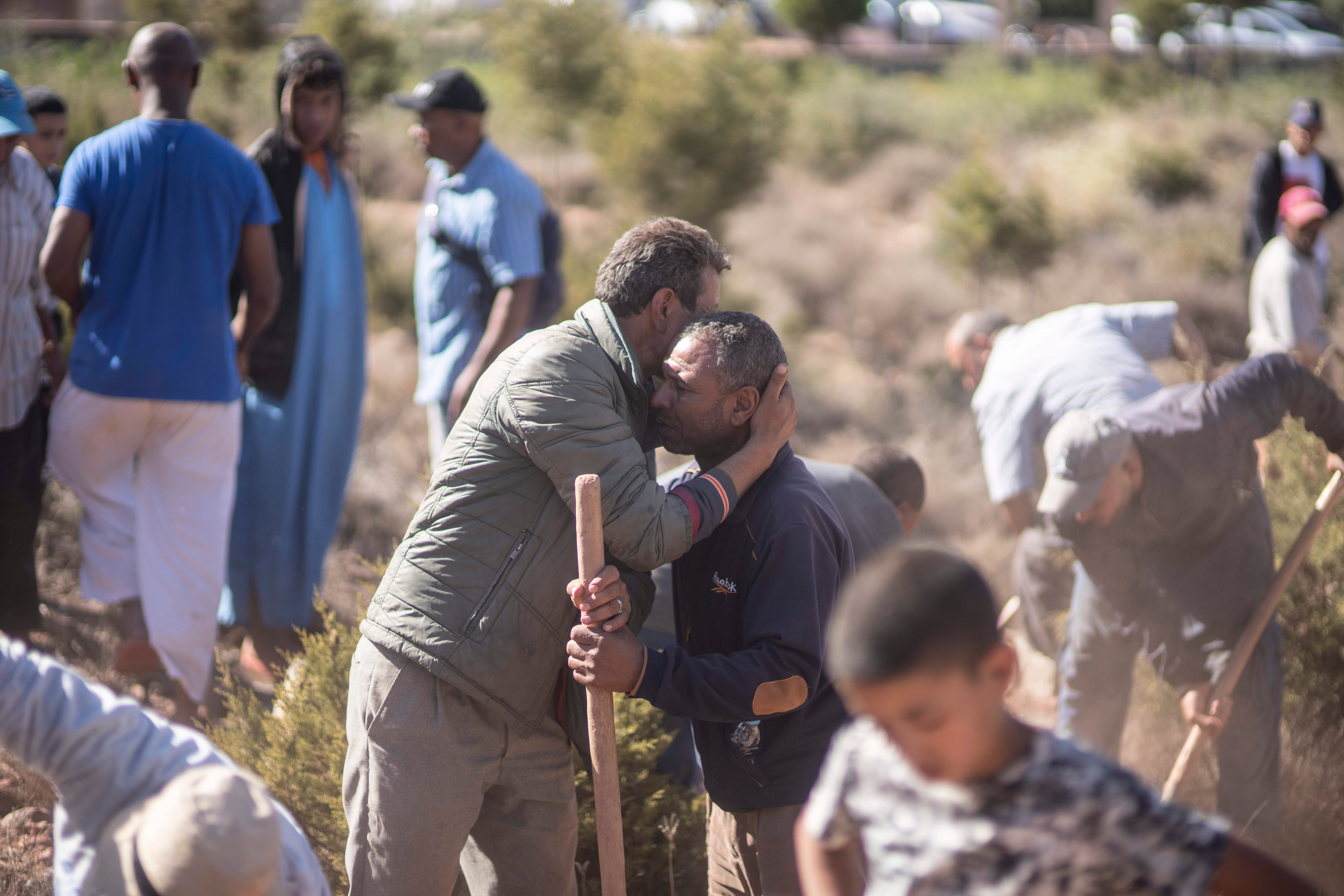 People comfort each other while digging graves for victims of the earthquake, in Ouargane village, near Marrakech on 9 September