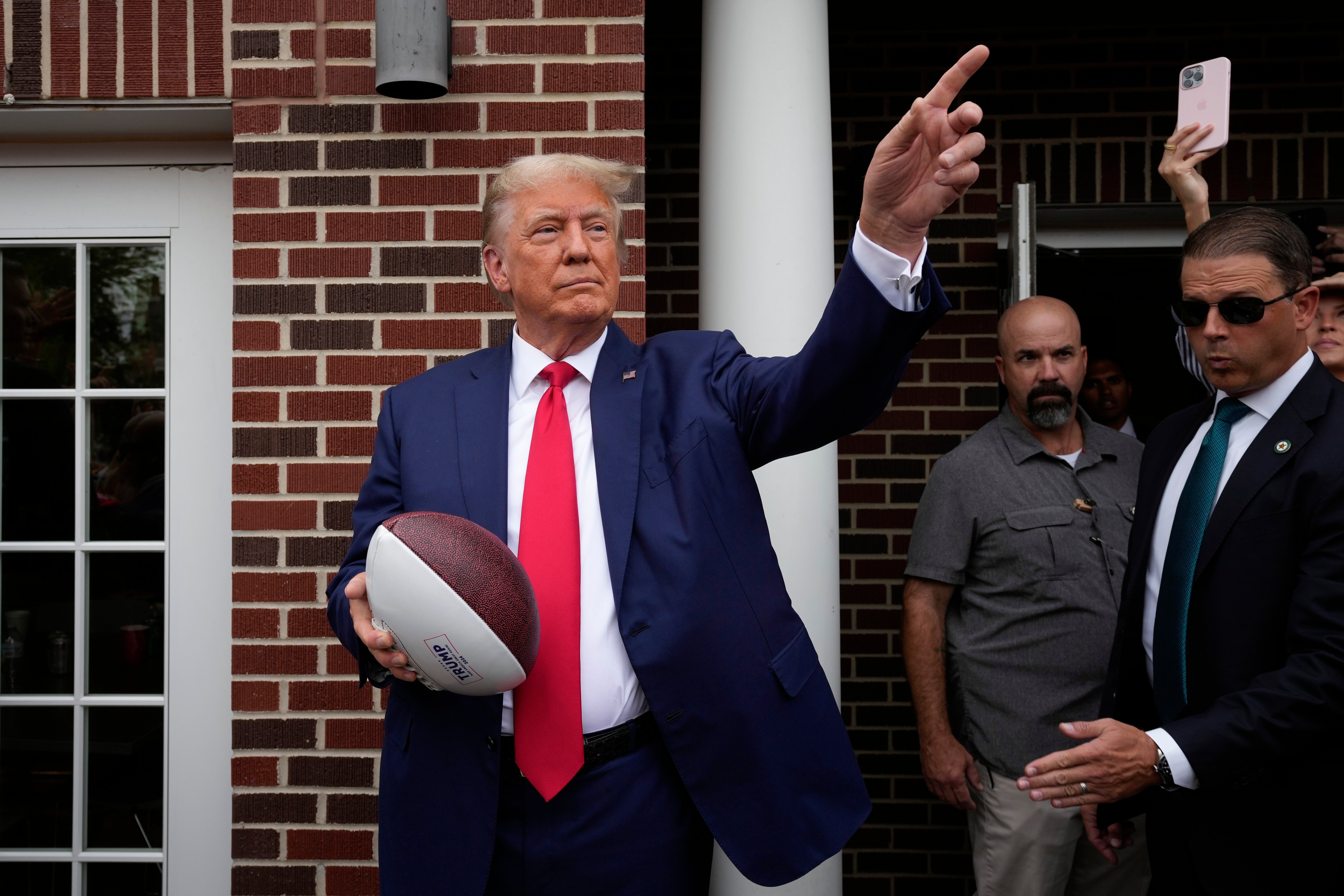 Donad Trump tossed footballs to a crowd at a fraternity house at Iowa State University on 9 September.