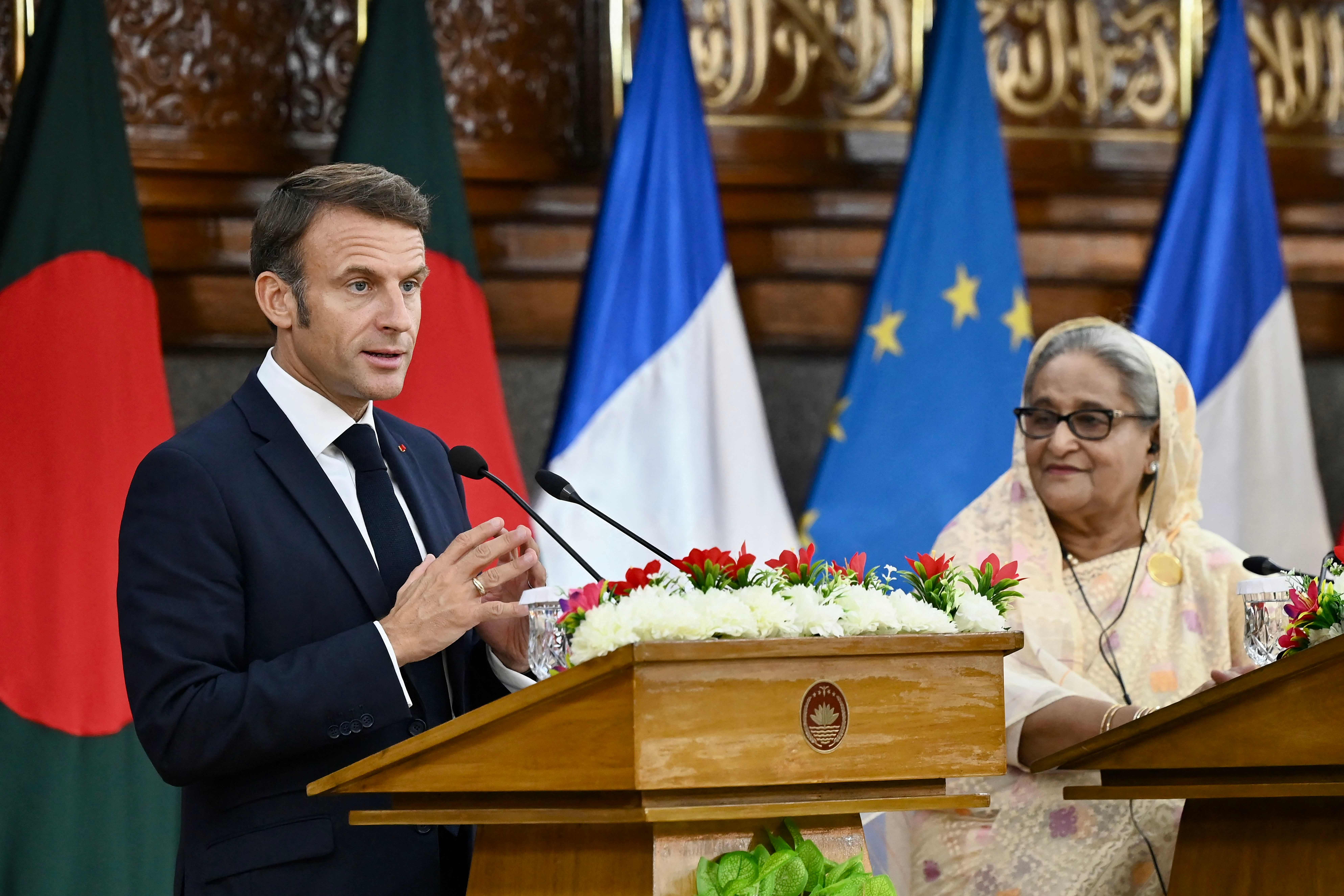 France’s president Emmanuel Macron (L) speaks as Bangladesh’s prime minister Sheikh Hasina looks on during the ceremony of signing bilateral agreements