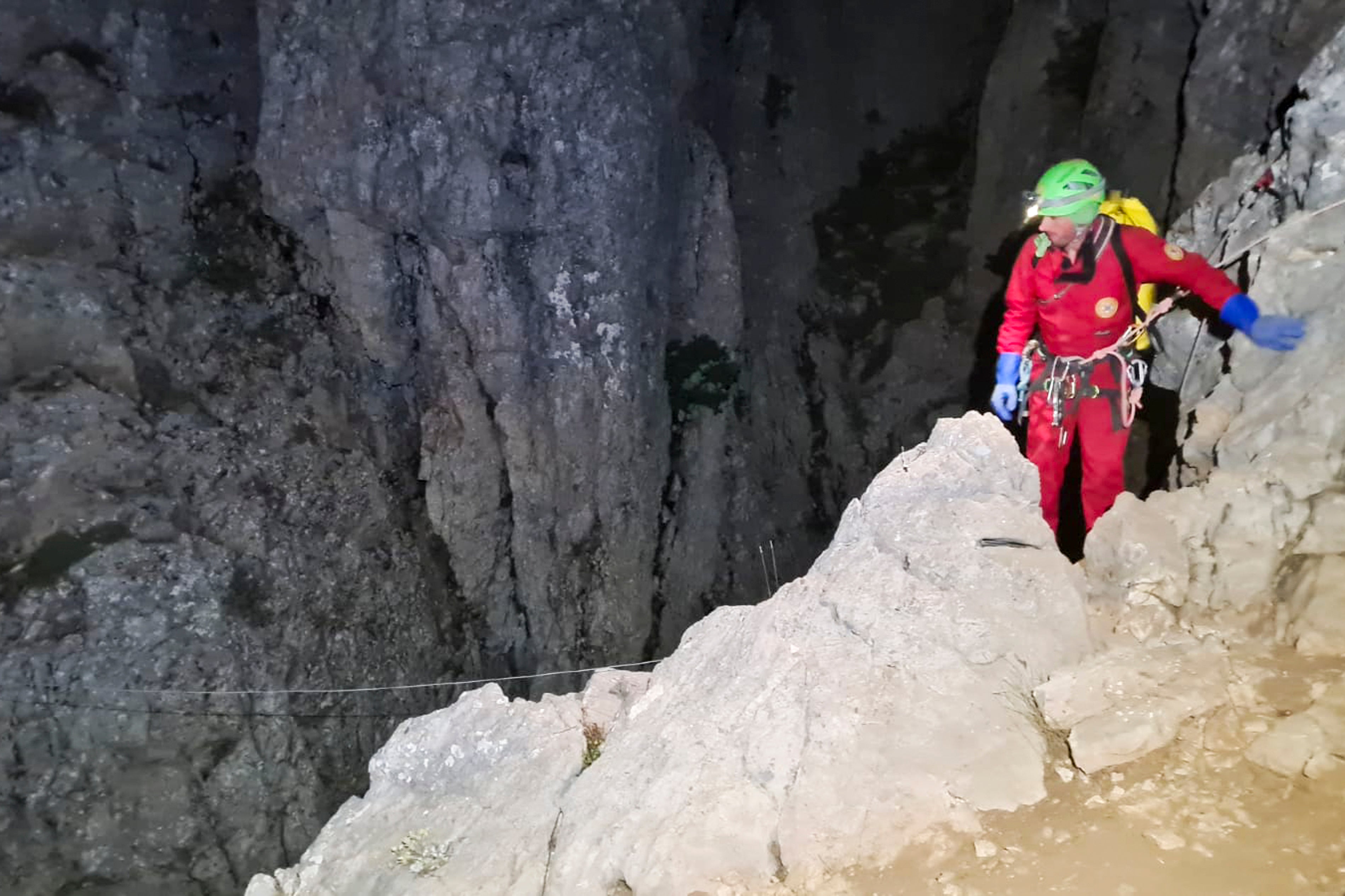 Members of the CNSAS, Italian alpine and speleological rescuers, start to descent on ropes