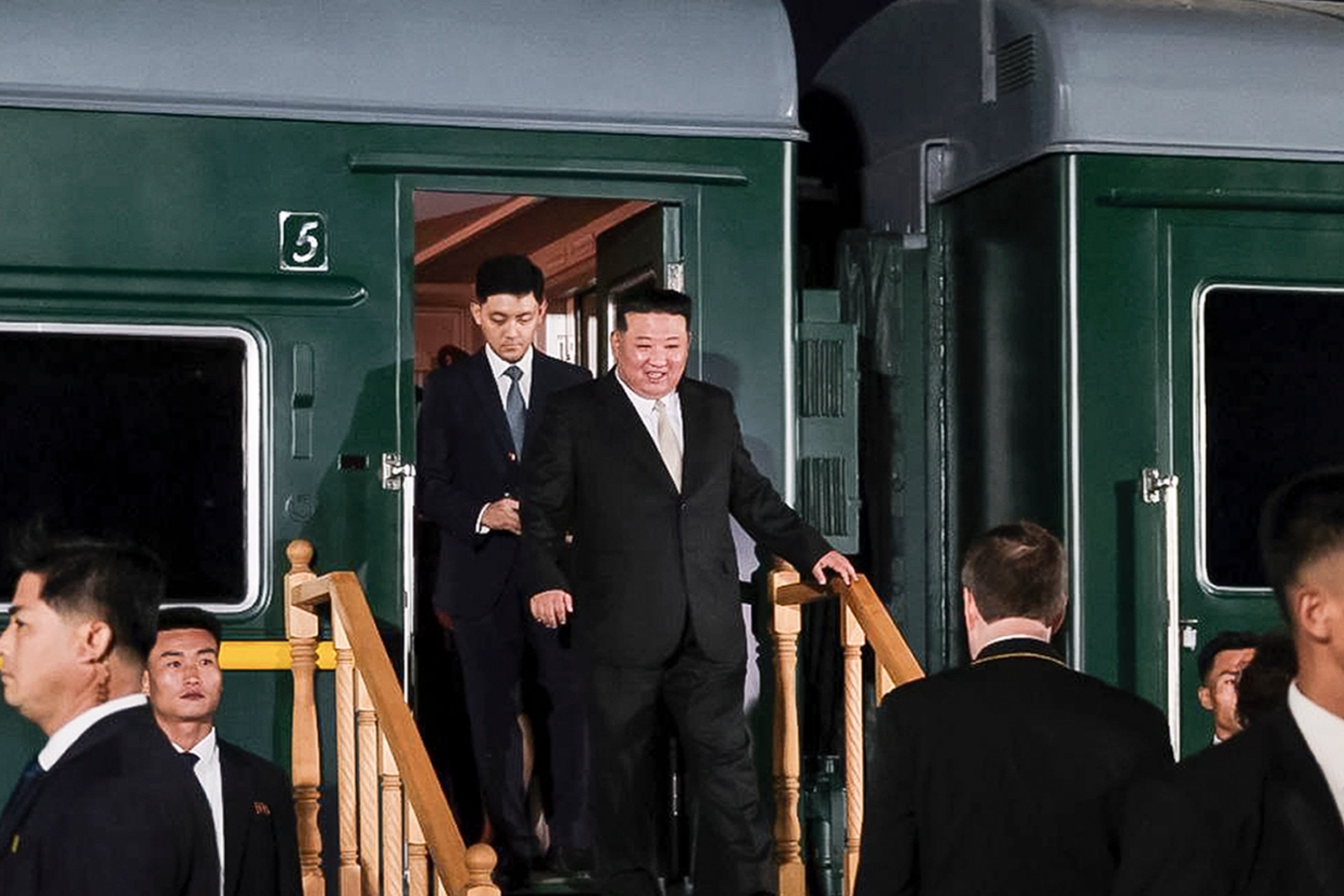 North Korea’s leader Kim Jong-un, center, steps down from his train after crossing the border to Russia at Khasan