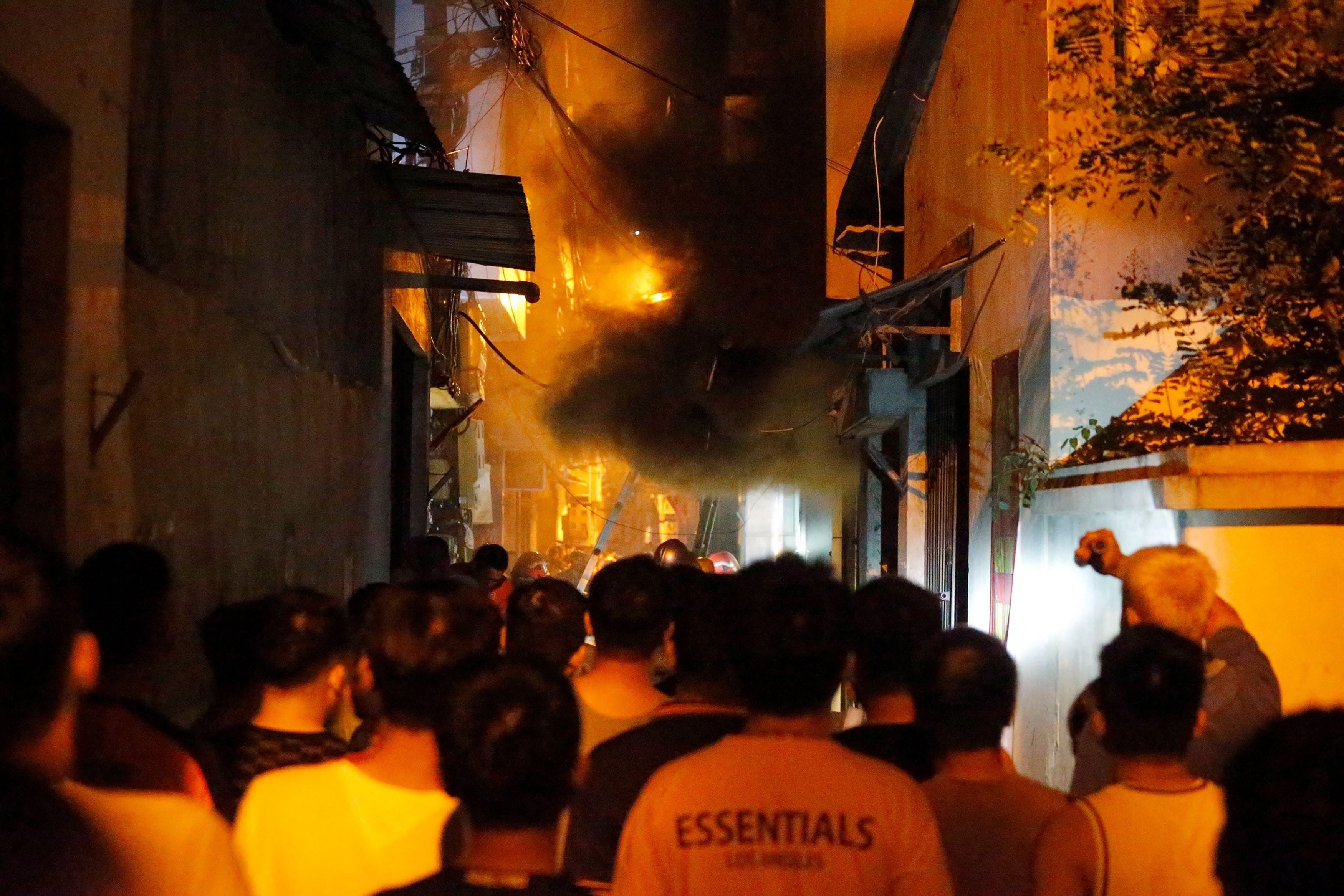 People watch a fire at an apartment building in Hanoi on 13 September