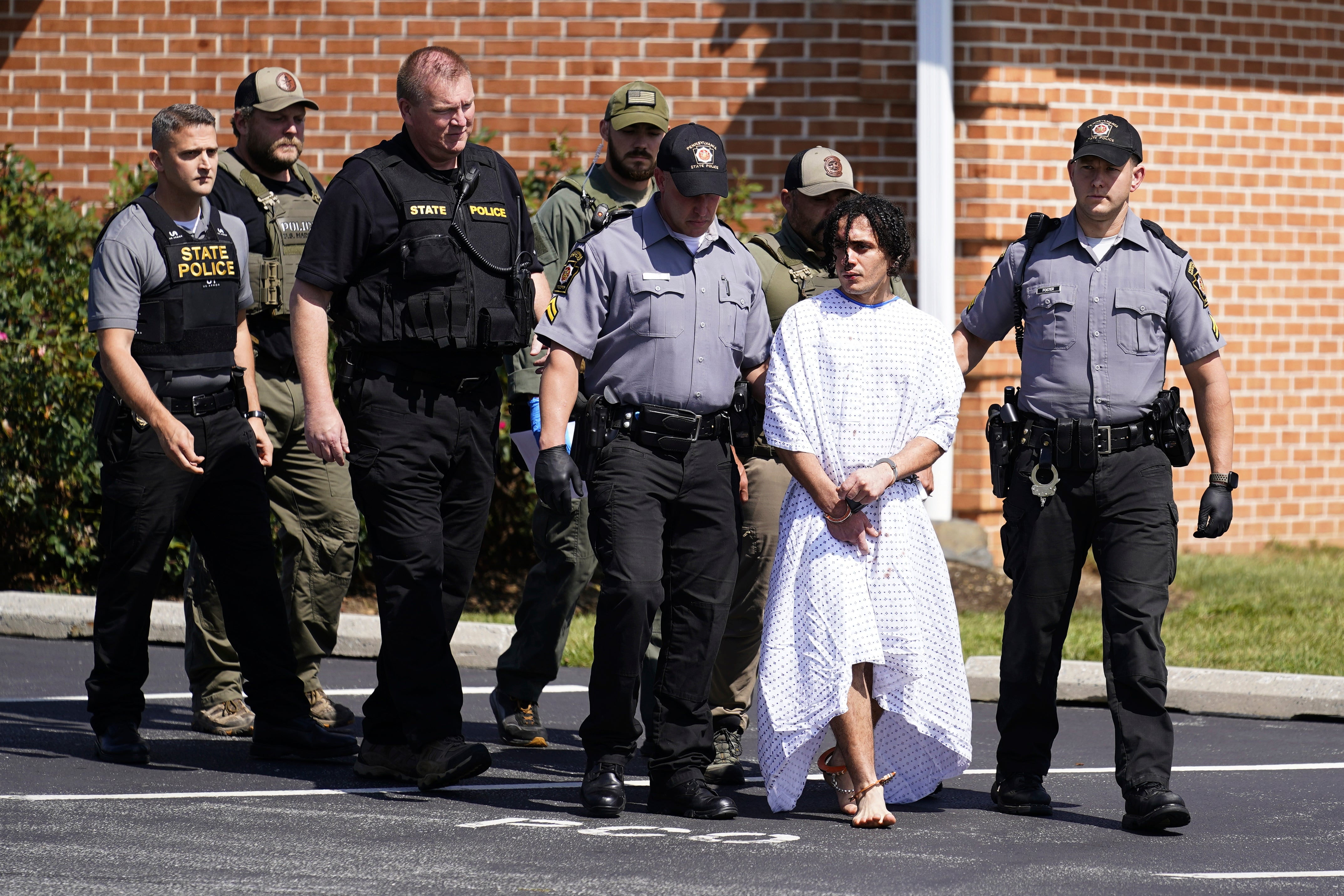 Law enforcement officers escort Danelo Cavalcante from a Pennsylvania State Police barracks in Avondale Pa