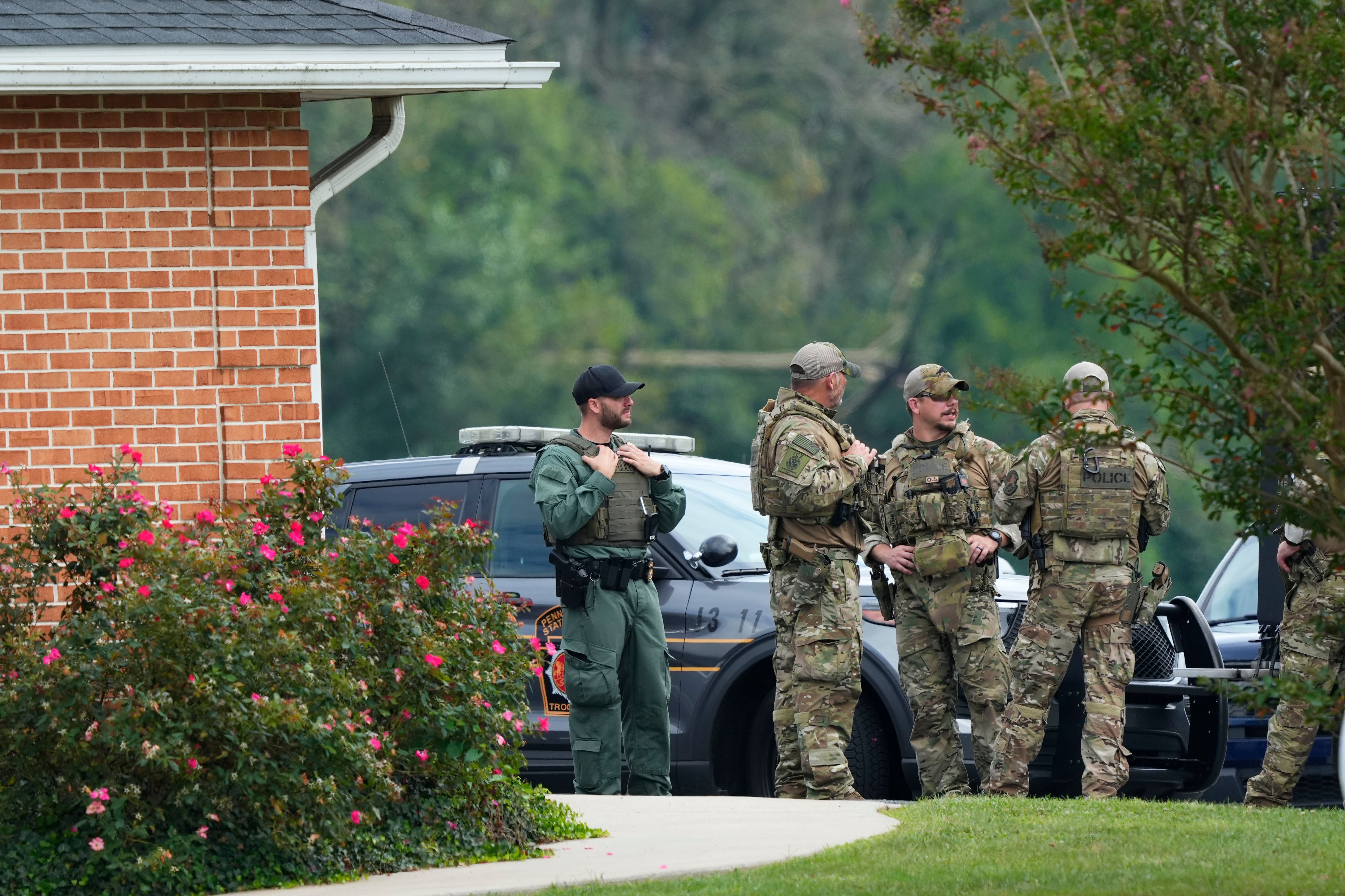 Law enforcement agents stand outside a Pennsylvania State Police barracks at Avondale Pa