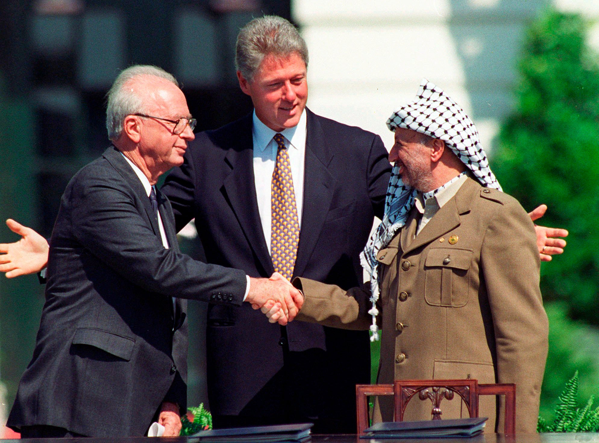 Israeli prime minister Yitzhak Rabin, left, and Palestinian leader Yasser Arafat shake hands marking the signing of the Oslo peace accords between Israel and the Palestinians, in Washington, September 1993