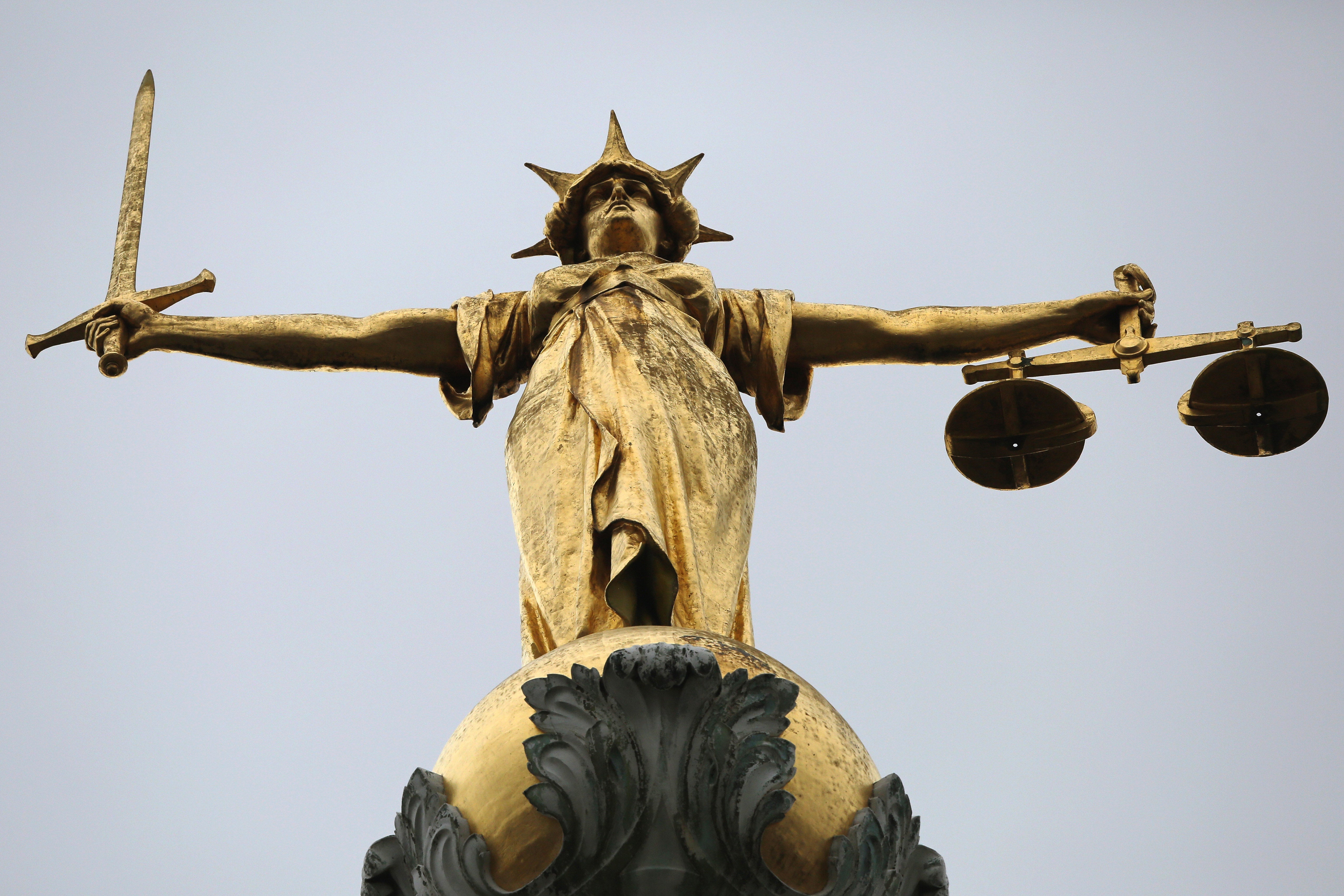 A statue of the scales of justice stands above the Old Bailey on February 16, 2015 in London, England