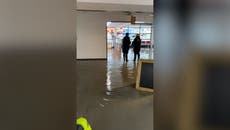 Passengers wade through flooded Exeter airport as month’s worth of rain falls in a day