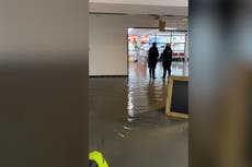 Passengers wade through flooded Exeter airport as month’s worth of rain falls in a day