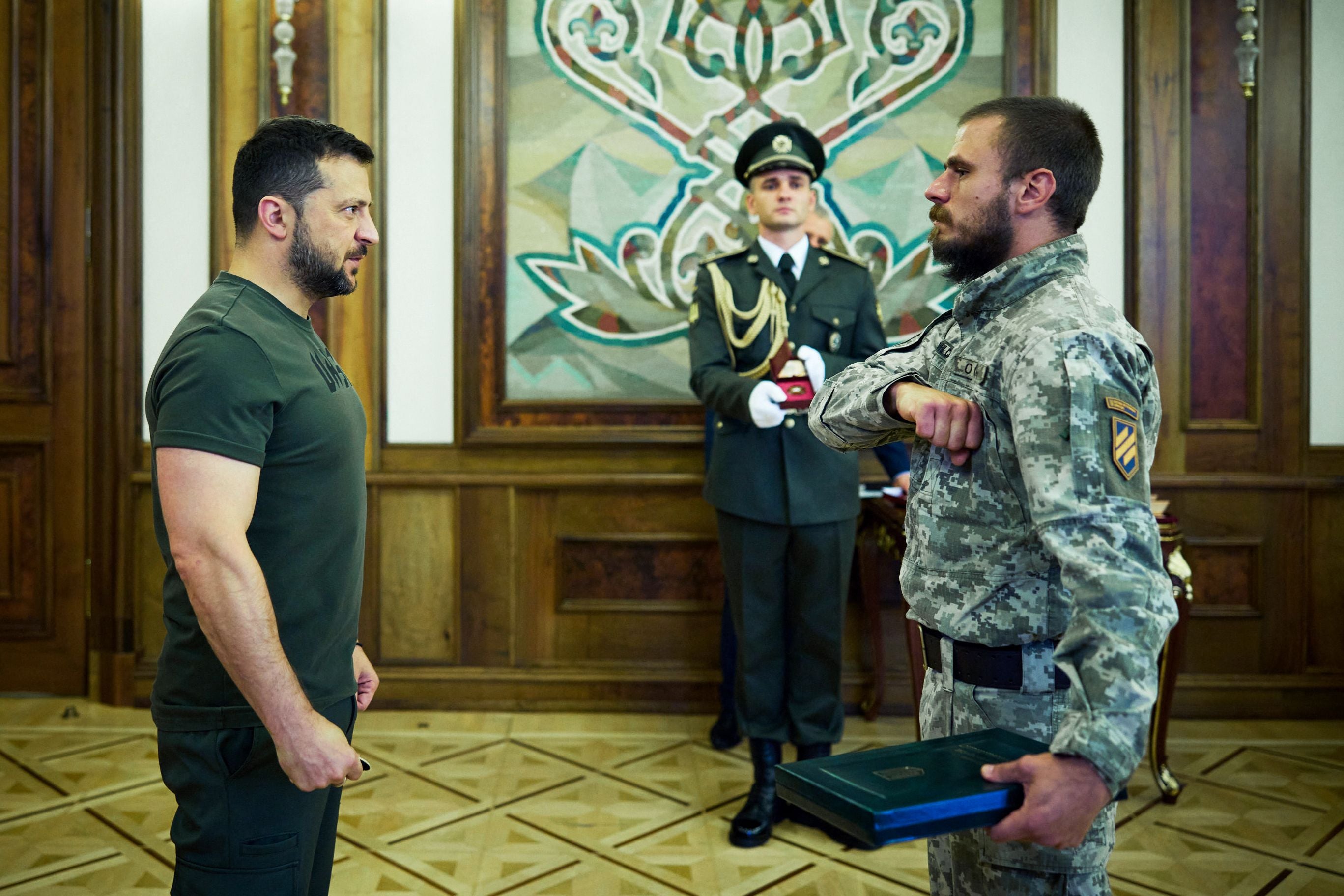 In this handout photograph taken and released by Ukrainian Presidential Press Service on September 14, 2023 Ukraine’s President Volodymyr Zelensky (L) gives an award to a serviceman during a ceremony marking Tank Troops Day in Kyiv