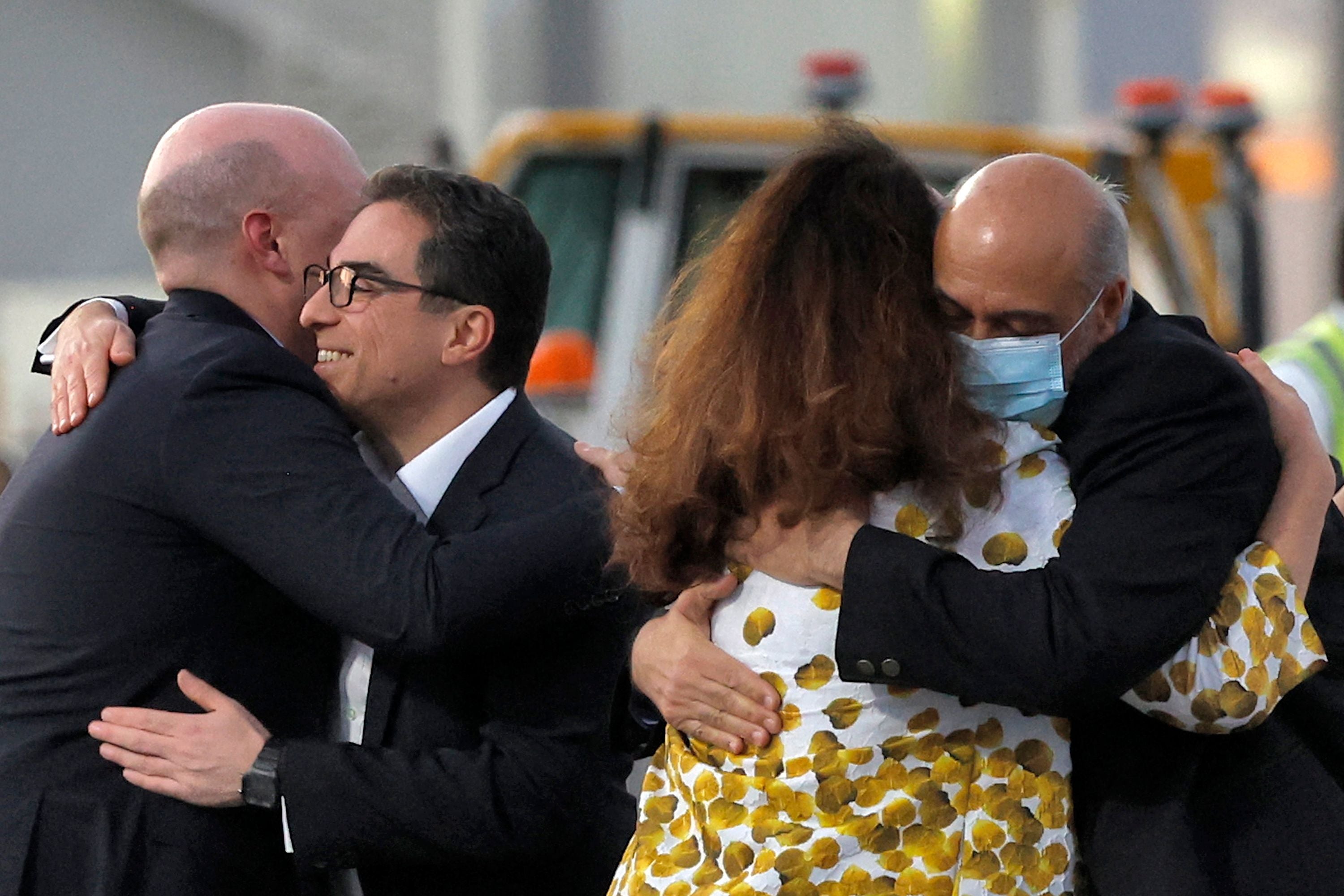 Mr Tahbaz (right, wearing mask) is welcomed on the tarmac at Doha airport after his release from Iran