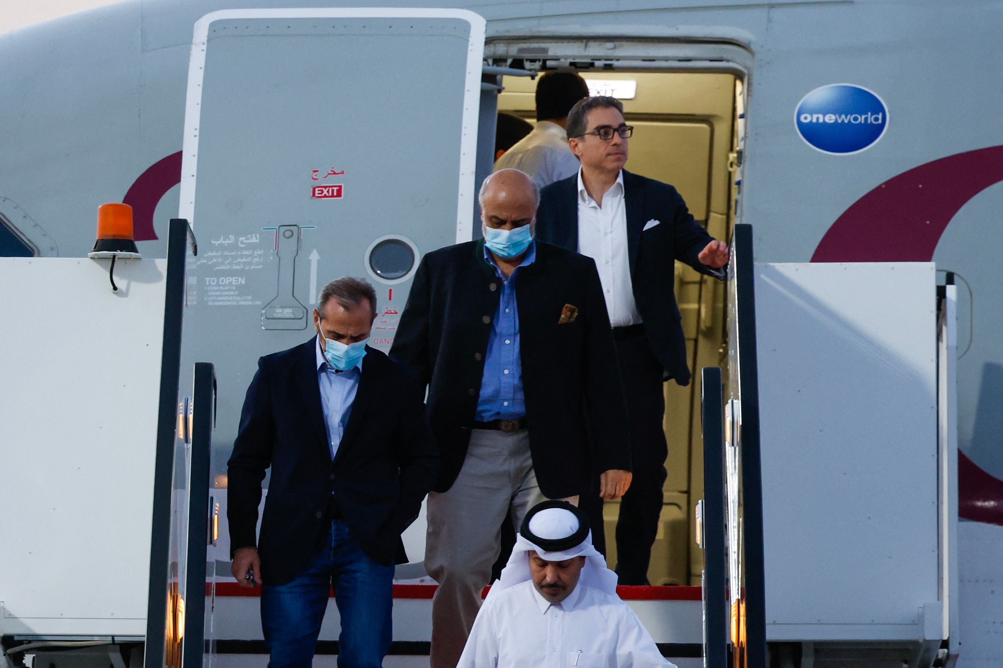 Mr Tahbaz, wearing a blue shirt, steps down onto the tarmac at Doha airport after his release from Iran