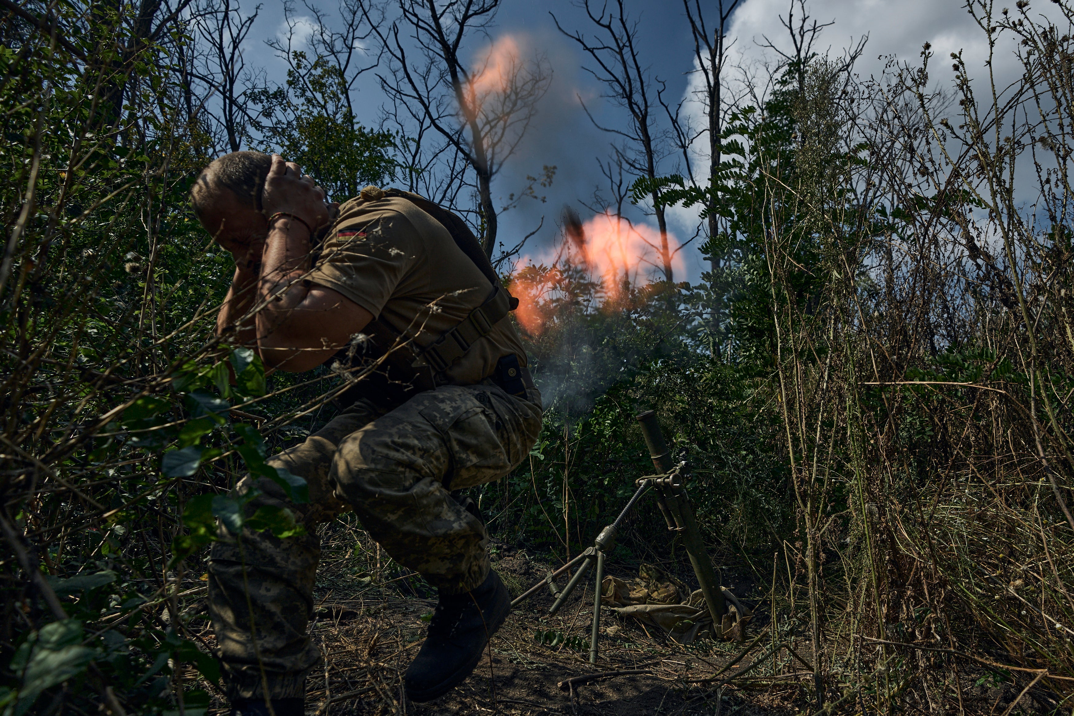 A Ukrainian soldier fires a mortar towards the Russian positions near Bakhmut