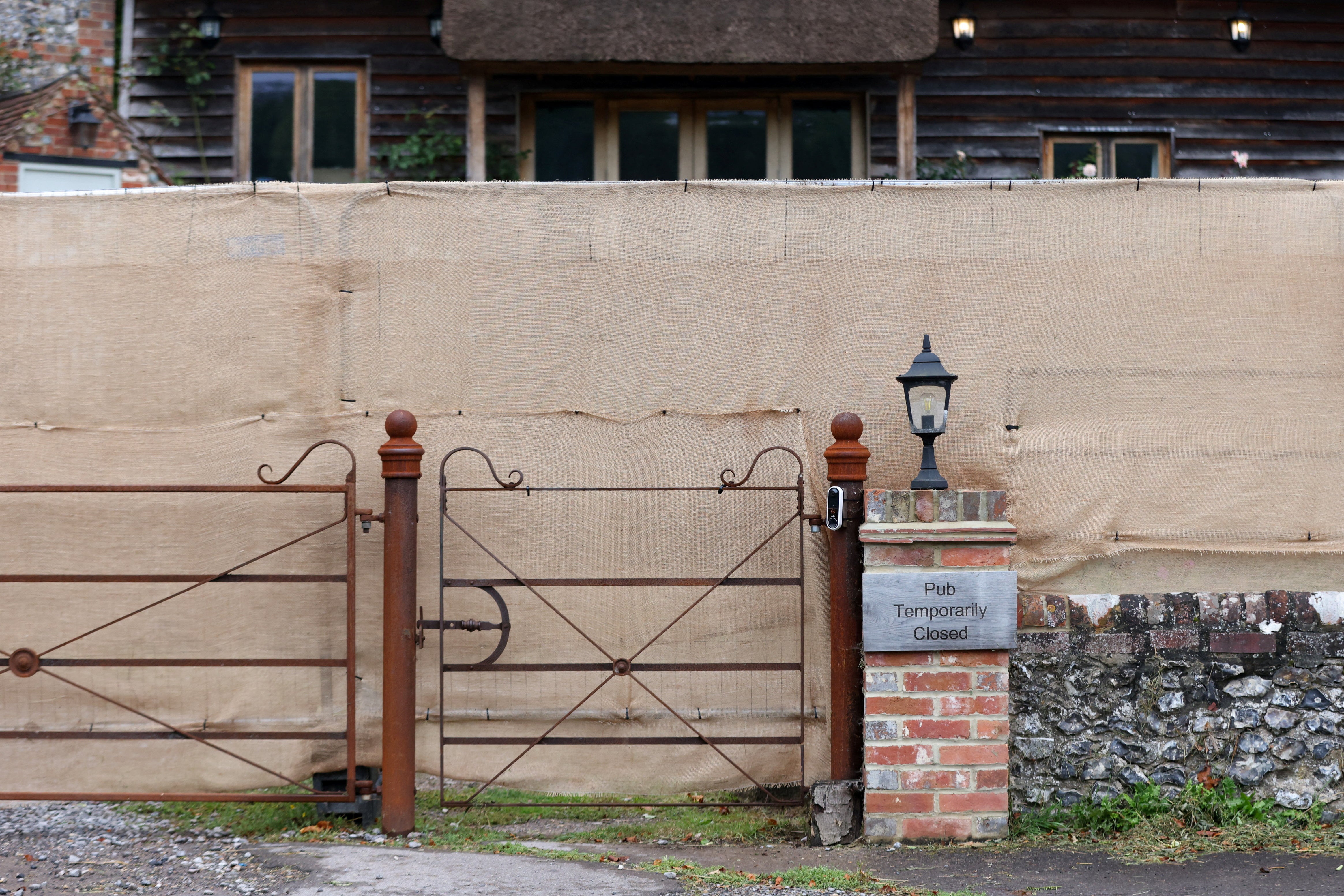 A large brown security fence outside The Crown Inn pub owned by Russell Brand’s company, in Pishill, Oxfordshire