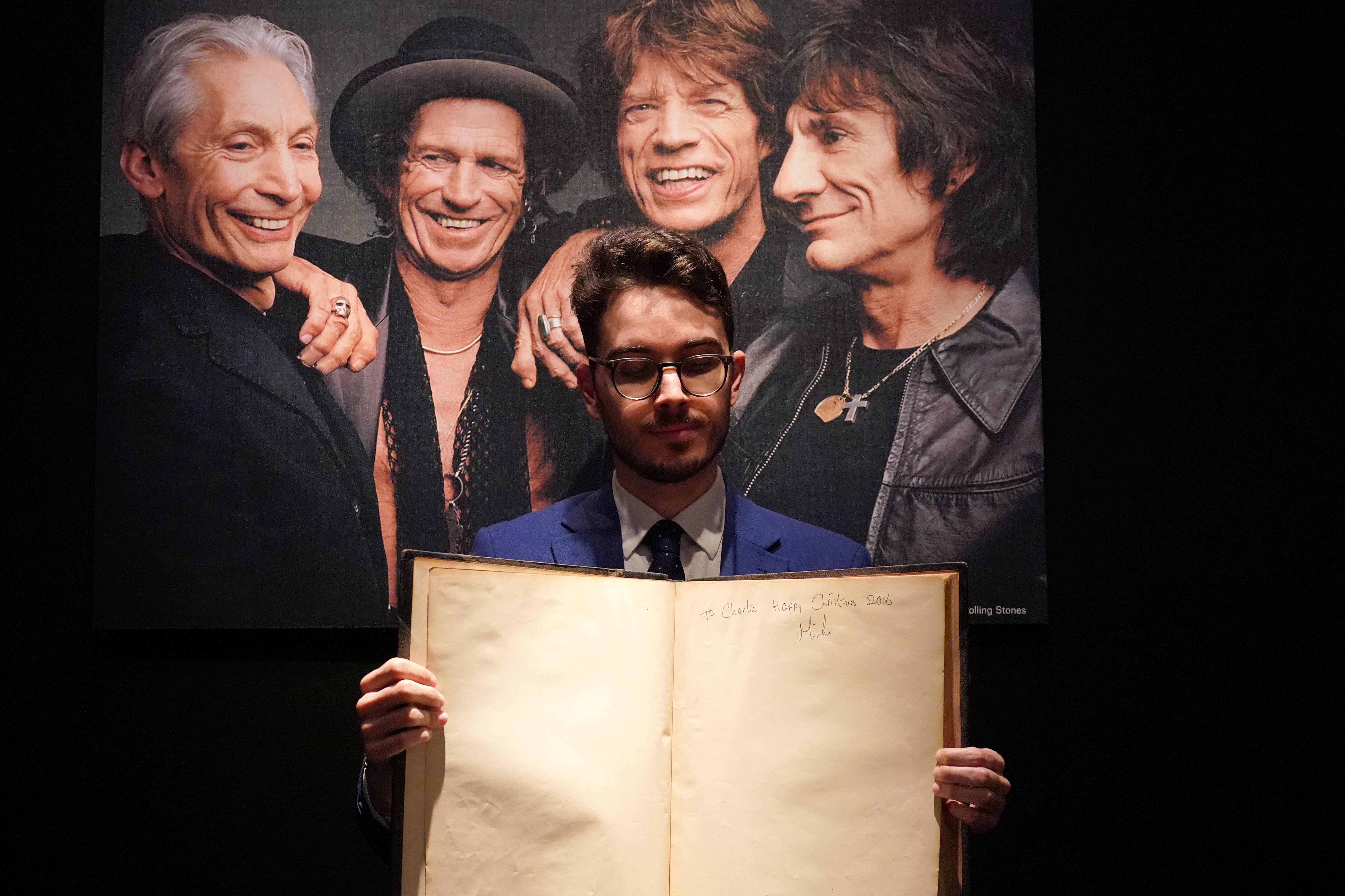 Christie’s books and manuscripts specialist Mark Wiltshire holds a first edition of Gustave Dore and Blanchard Jerrold’s London, A Pilgrimage, inscribed by Sir Mick Jagger (Jonathan Brady/PA)