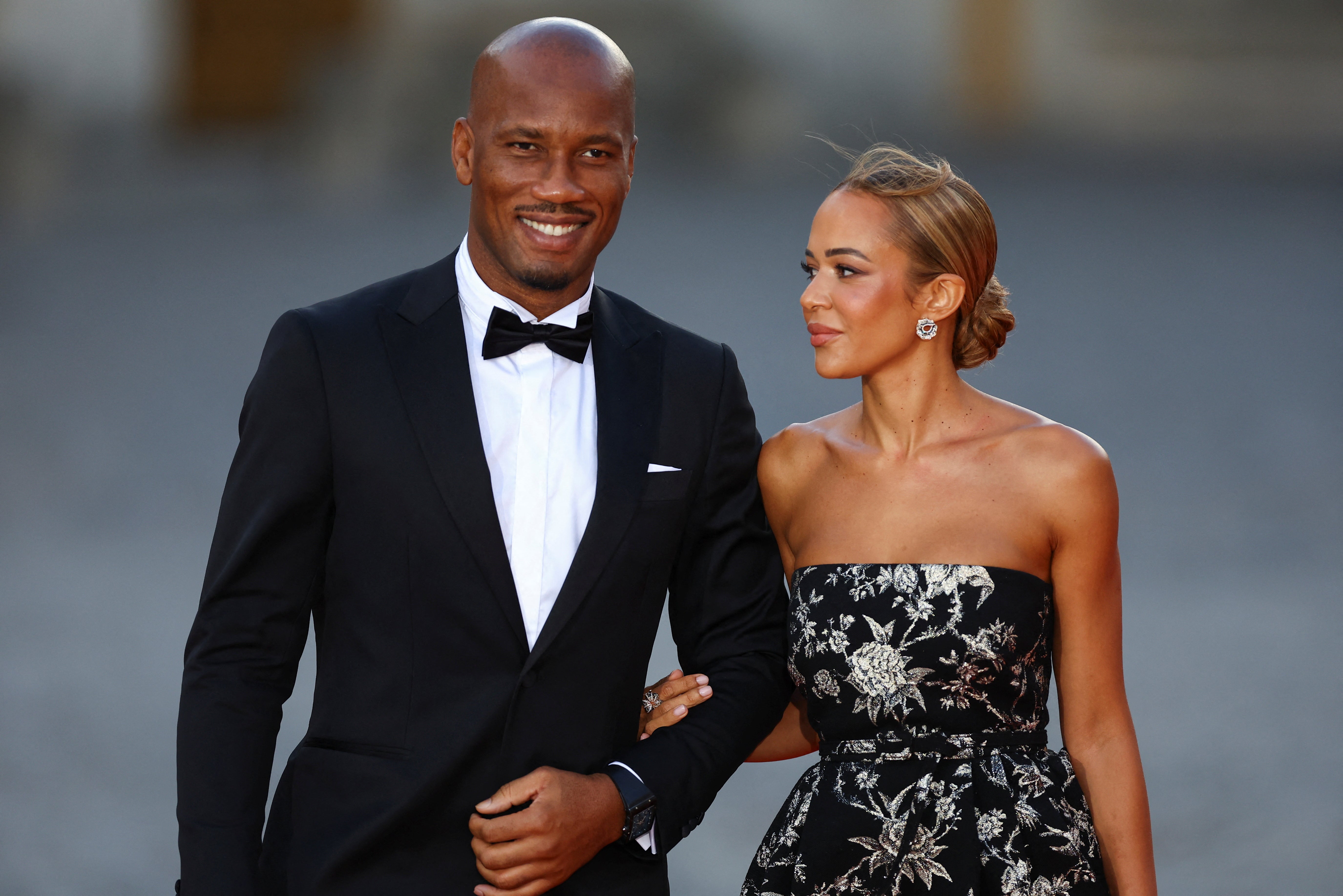 Didier Drogba and Gabrielle Lemaire arrive to attend a state dinner in honor of Britain's King Charles and Queen Camilla at the Chateau de Versailles