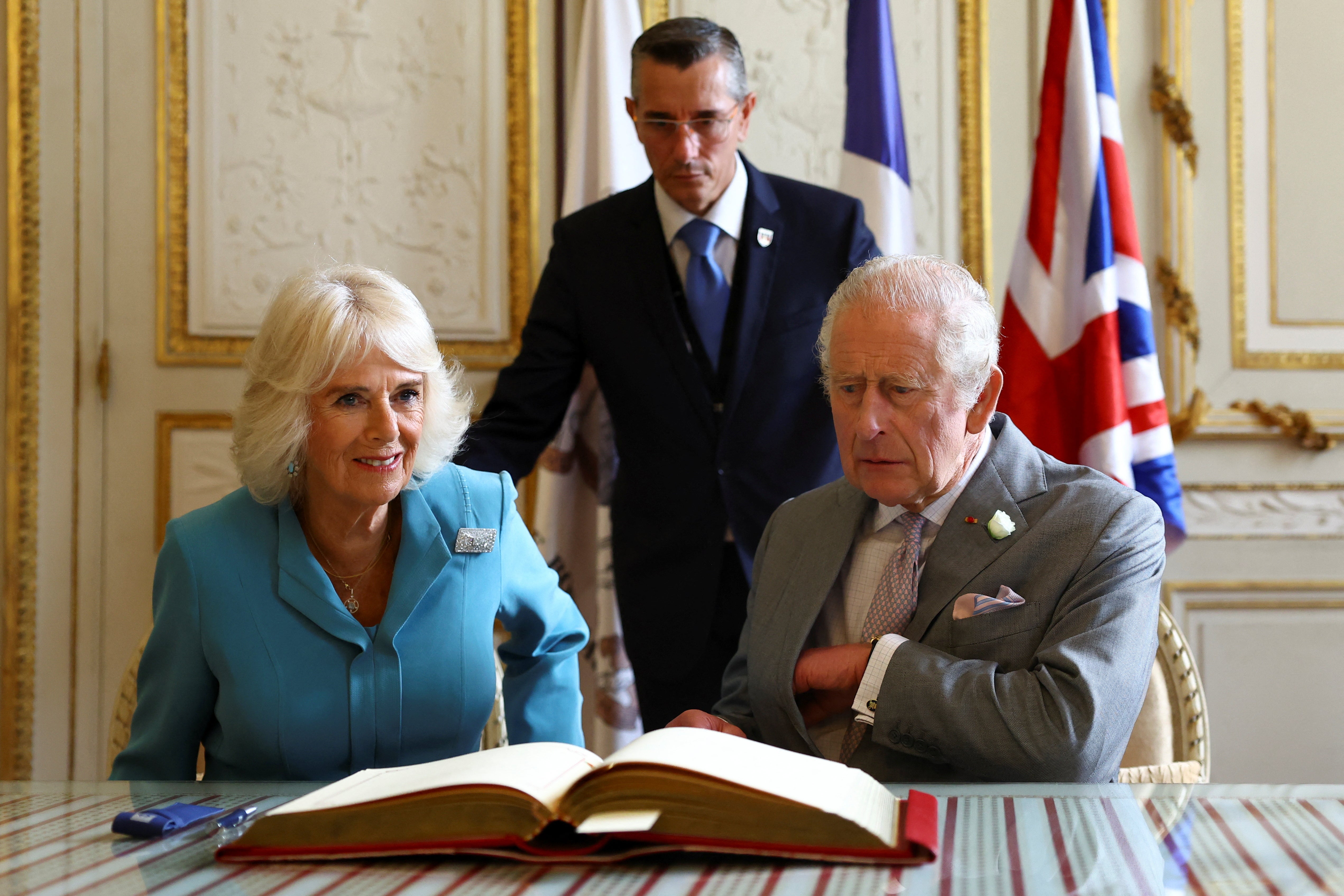 The royal couple signing the visitor book at the Hotel de Ville