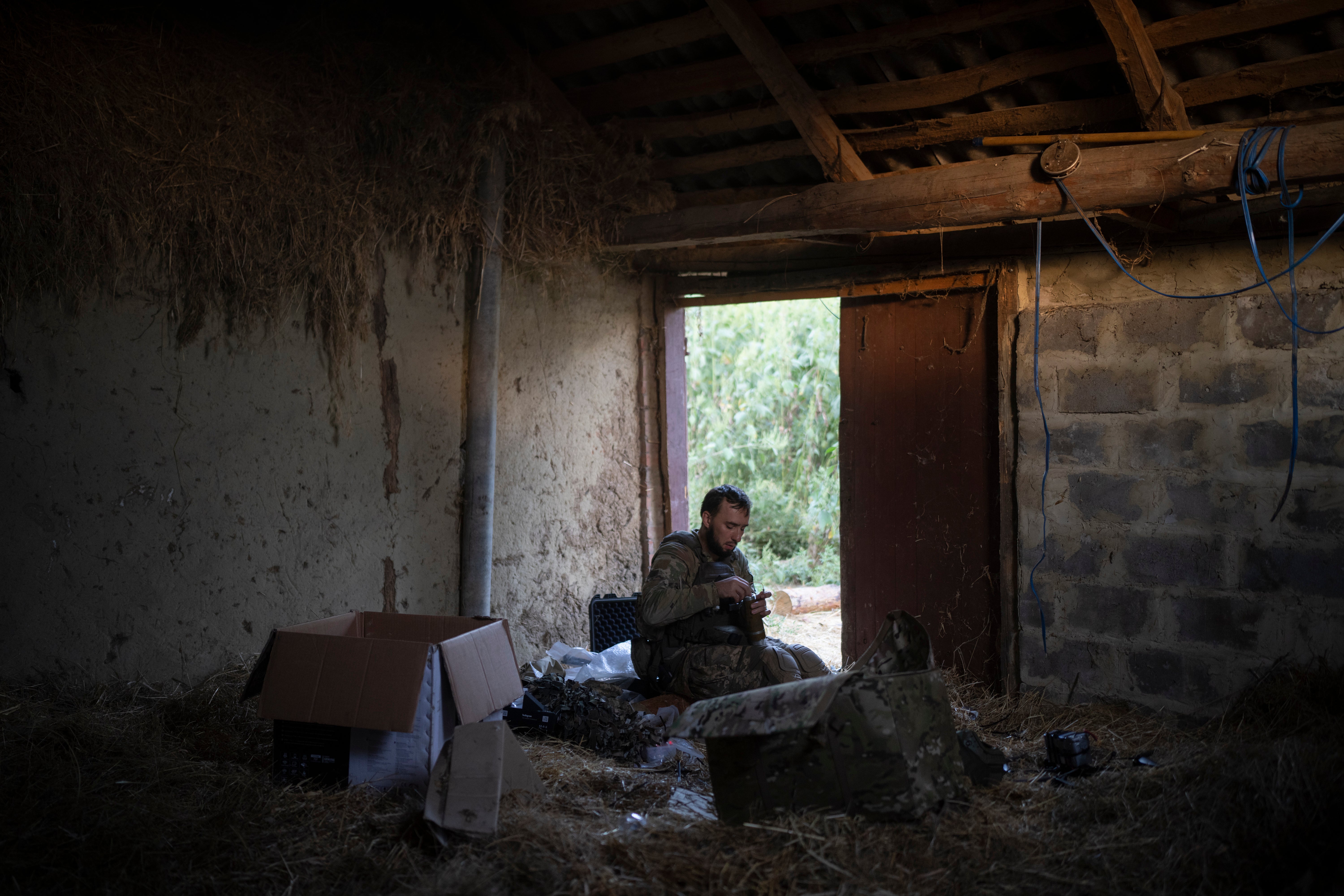 Stem, a member of the elite Ukrainian drone unit, attaches a bomb to an exploding drone in the outskirts of Kremmina, Ukraine