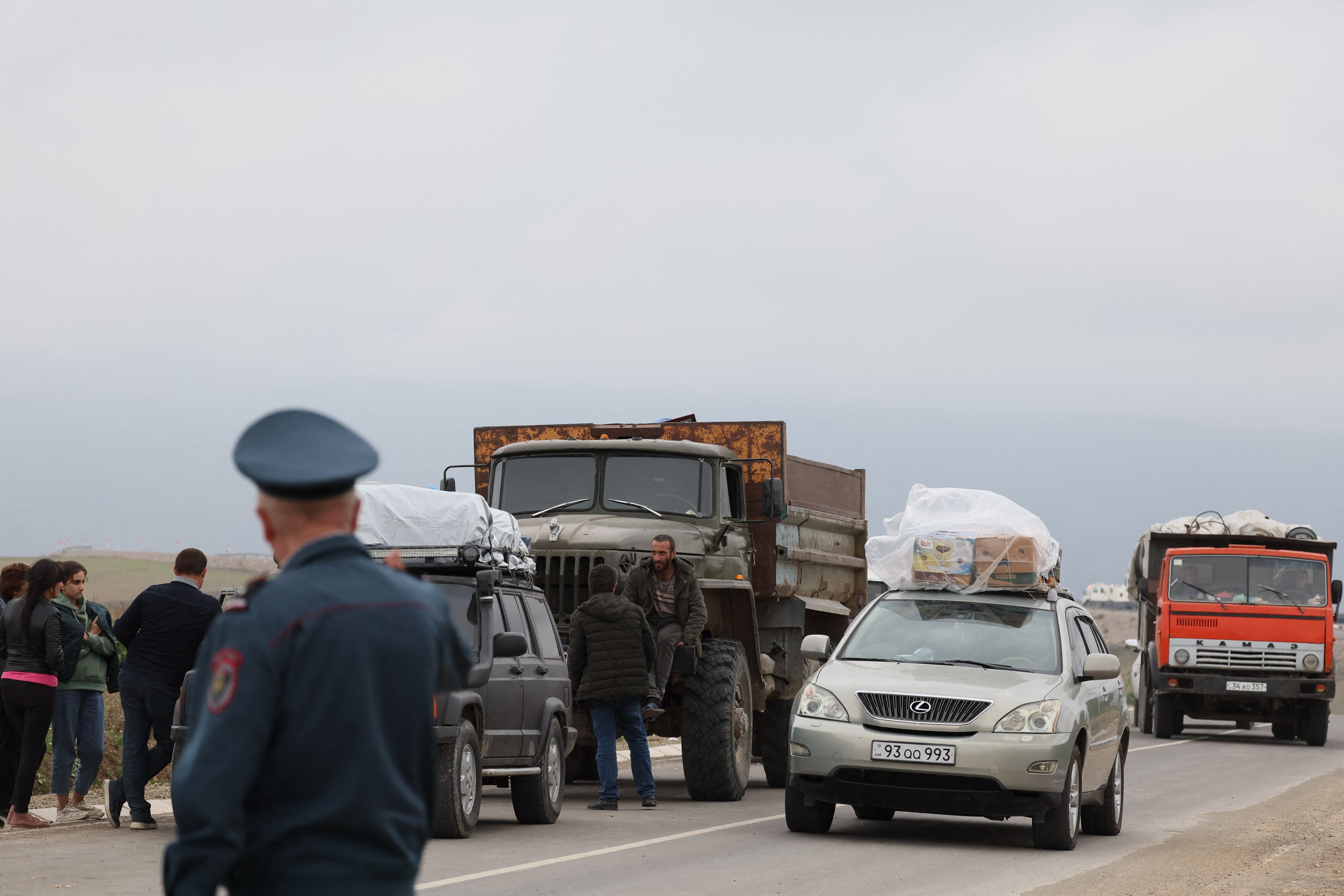 Refugees wait after crossing the border and arriving at a registration centre of the Armenian foreign affairs ministry