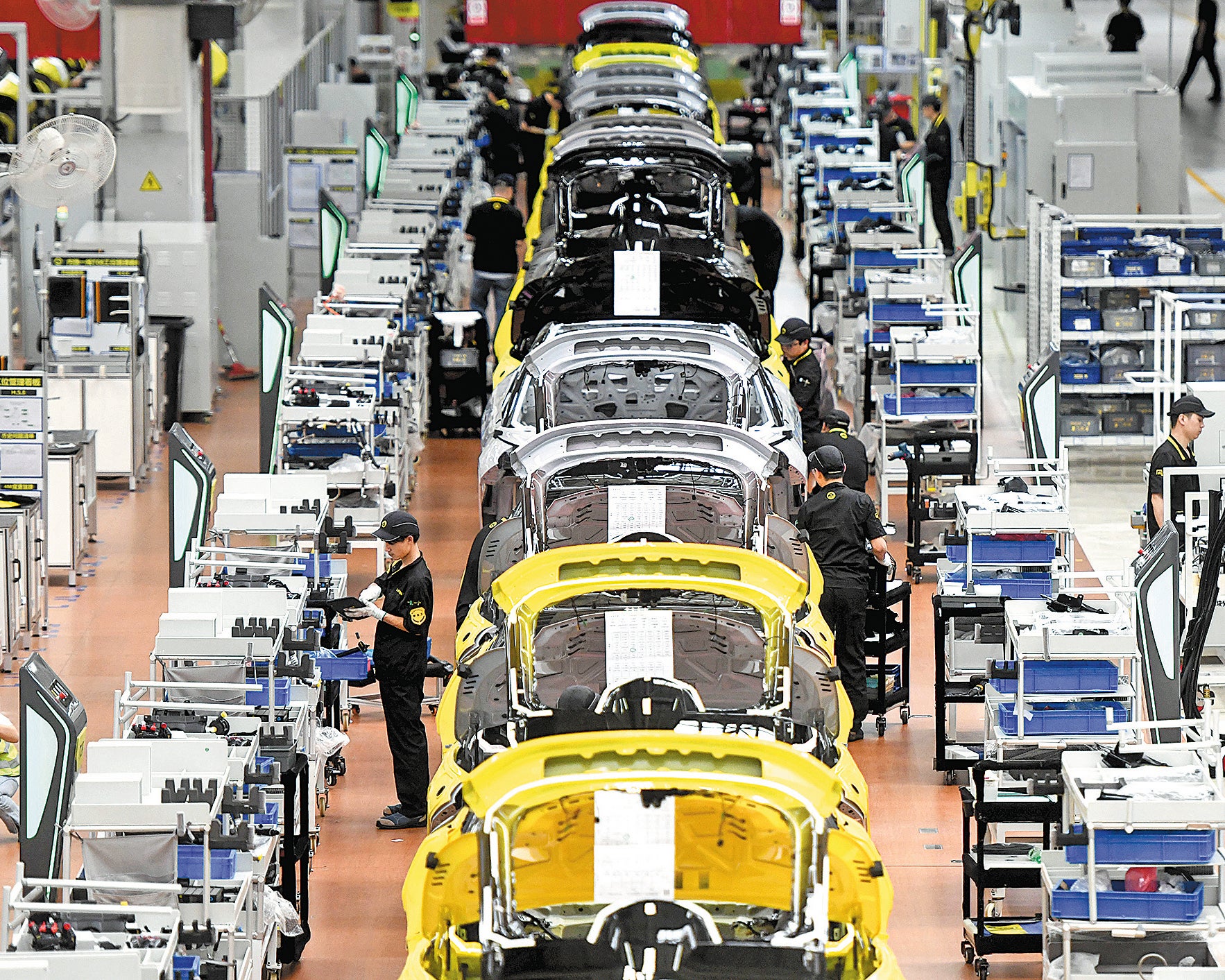 Workers operate machinery on the production line at a smart factory in Wuhan, Hubei province