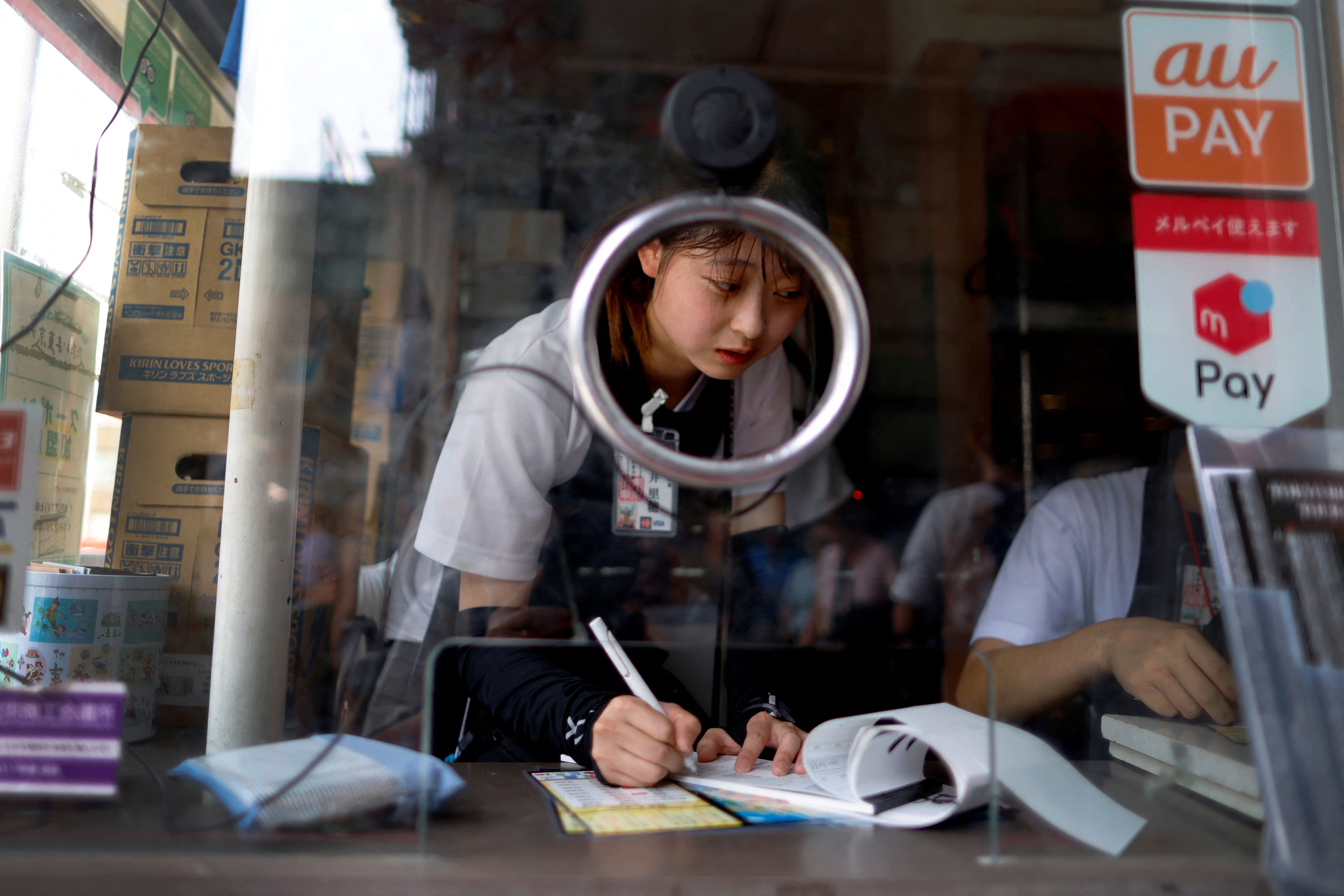 Novice rickshaw puller Riho Arai, 19, takes a break inside the ticket booth