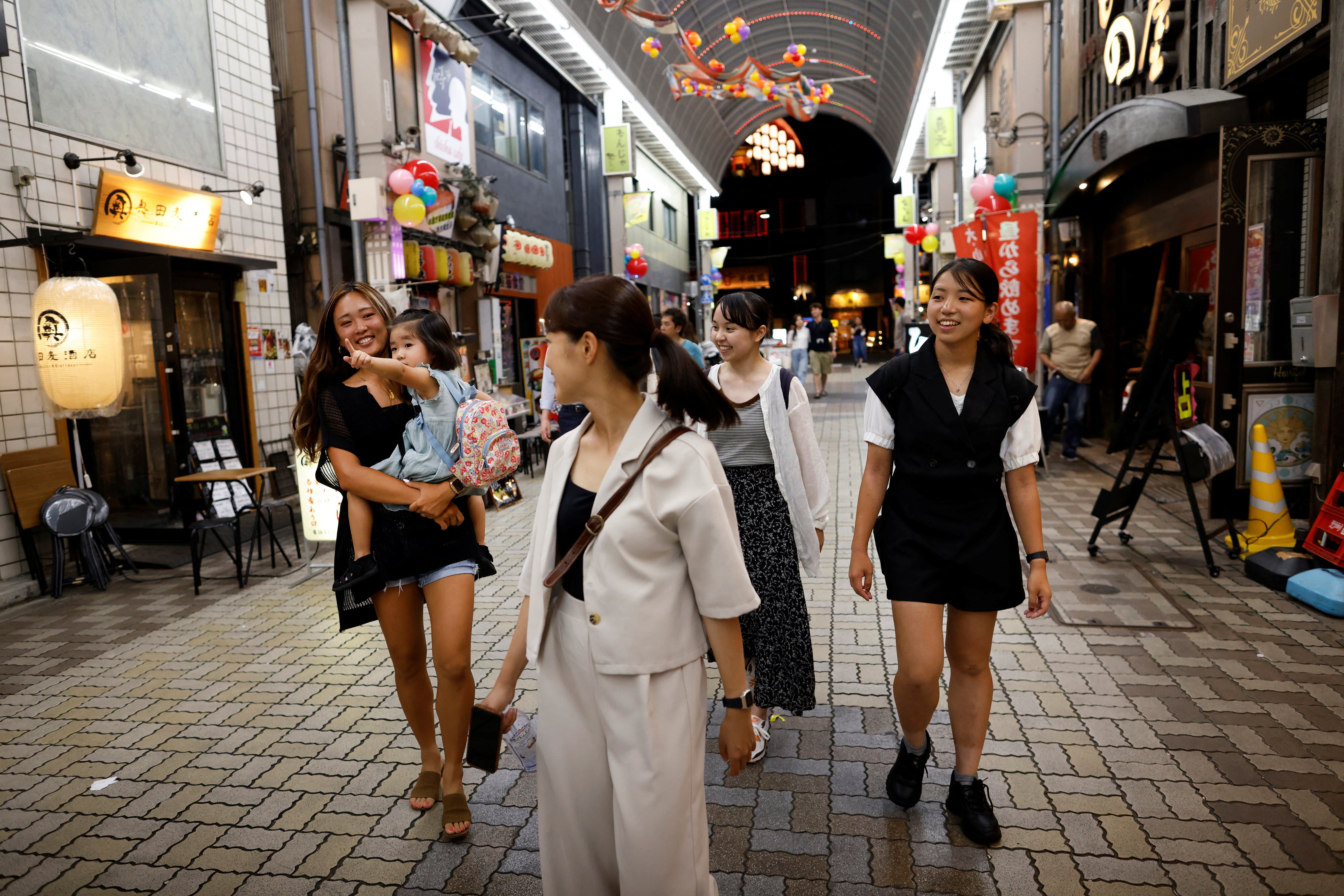 Rickshaw puller Shiori Yoshida, 28, and her daughter Yui, 3, meet colleagues after work