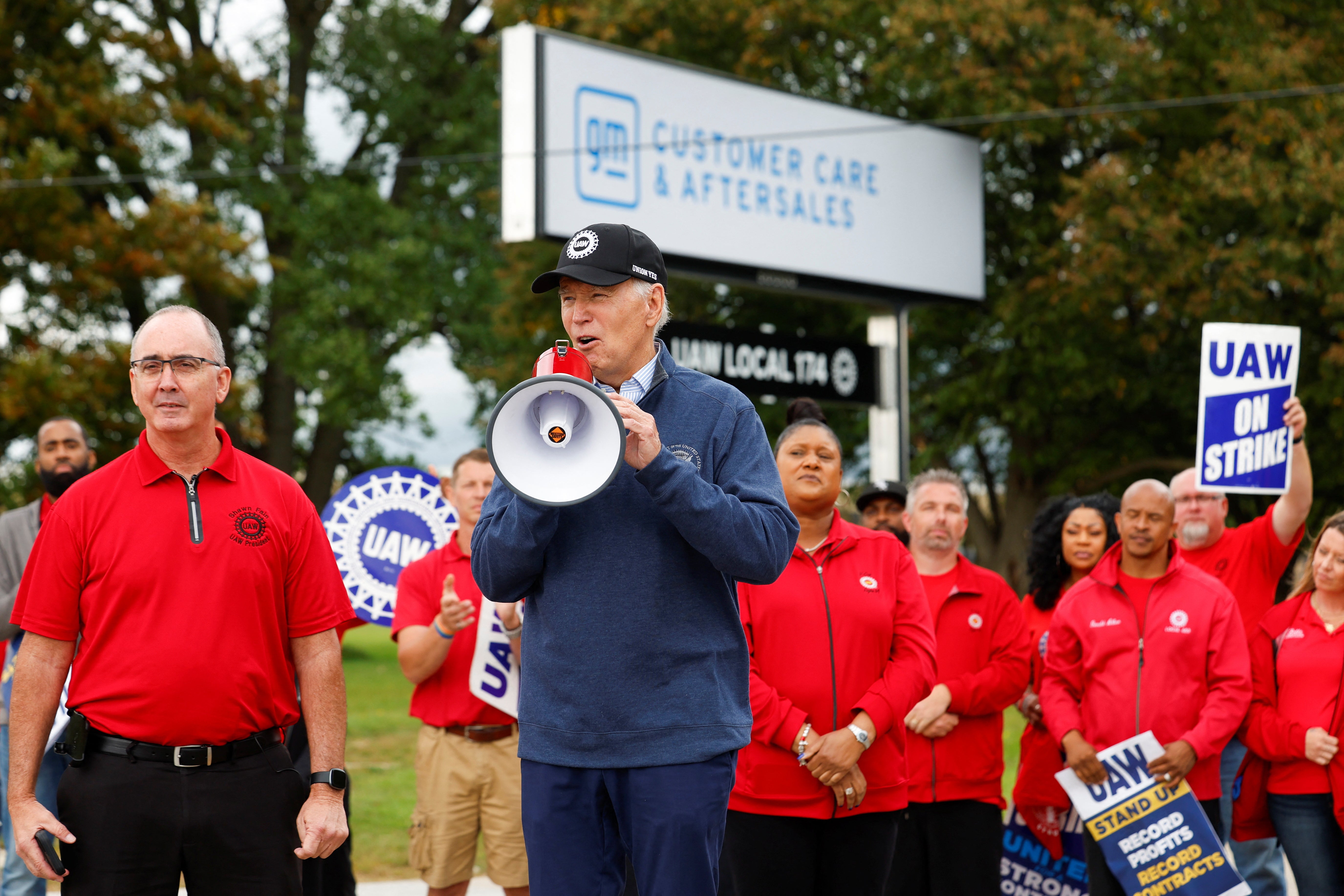 U.S. President Joe Biden speaks next to Shawn Fain, President of the United Auto Workers (UAW), as he joins striking members of the United Auto Workers (UAW) on the picket line outside the GM's Willow Run Distribution Center, in Bellville, Wayne County, Michigan, U.S., September 26, 2023