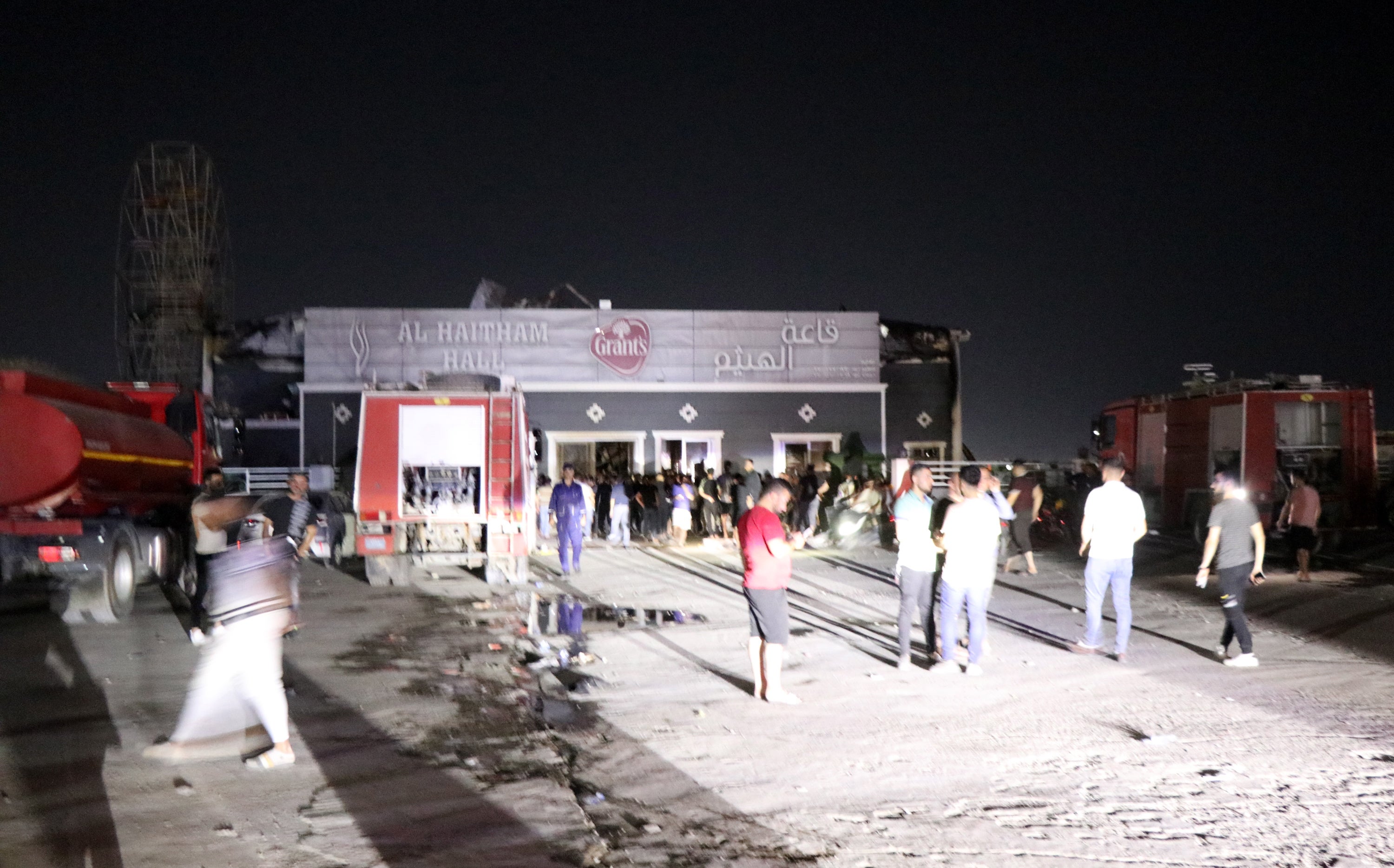 People gather outside at the scene of a fire that broke out at a wedding hall in Hamdaniya, in Iraq’s Nineveh province, north of Iraq, 27 September 2023