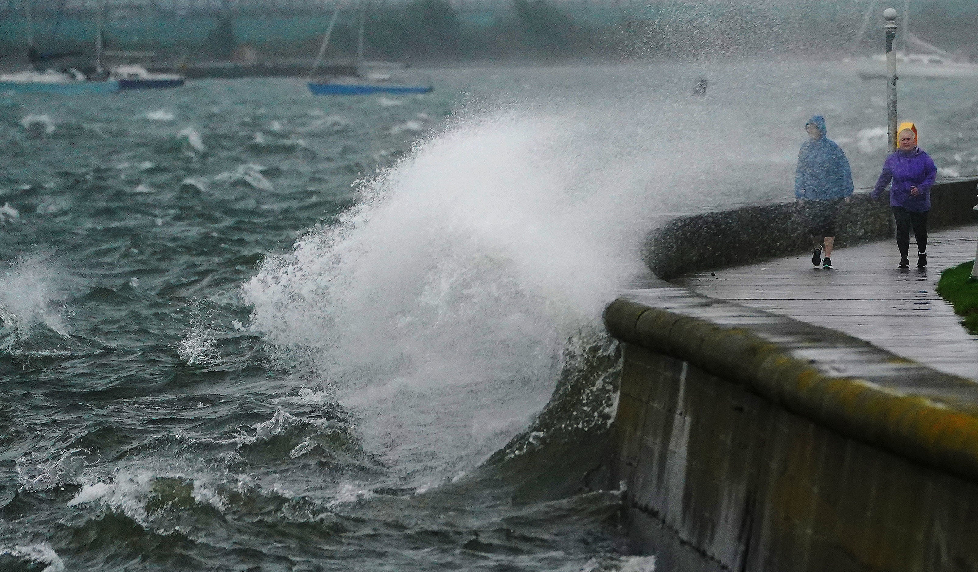 People walk along the Clontarf promenade, Dublin, as Storm Agnes lands