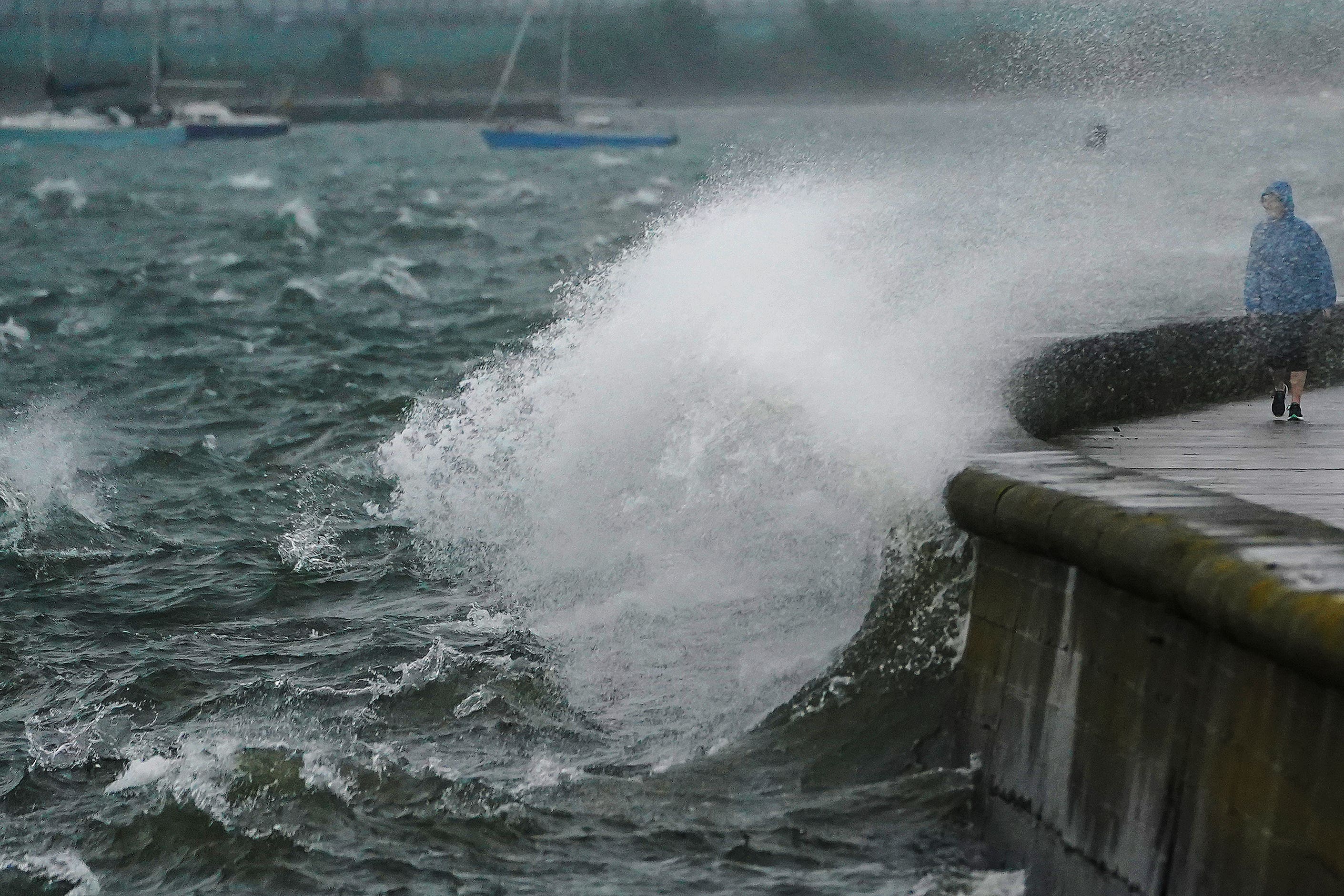 People walk along the Clontarf promenade, Dublin, as Storm Agnes lands (Brian Lawless/PA)