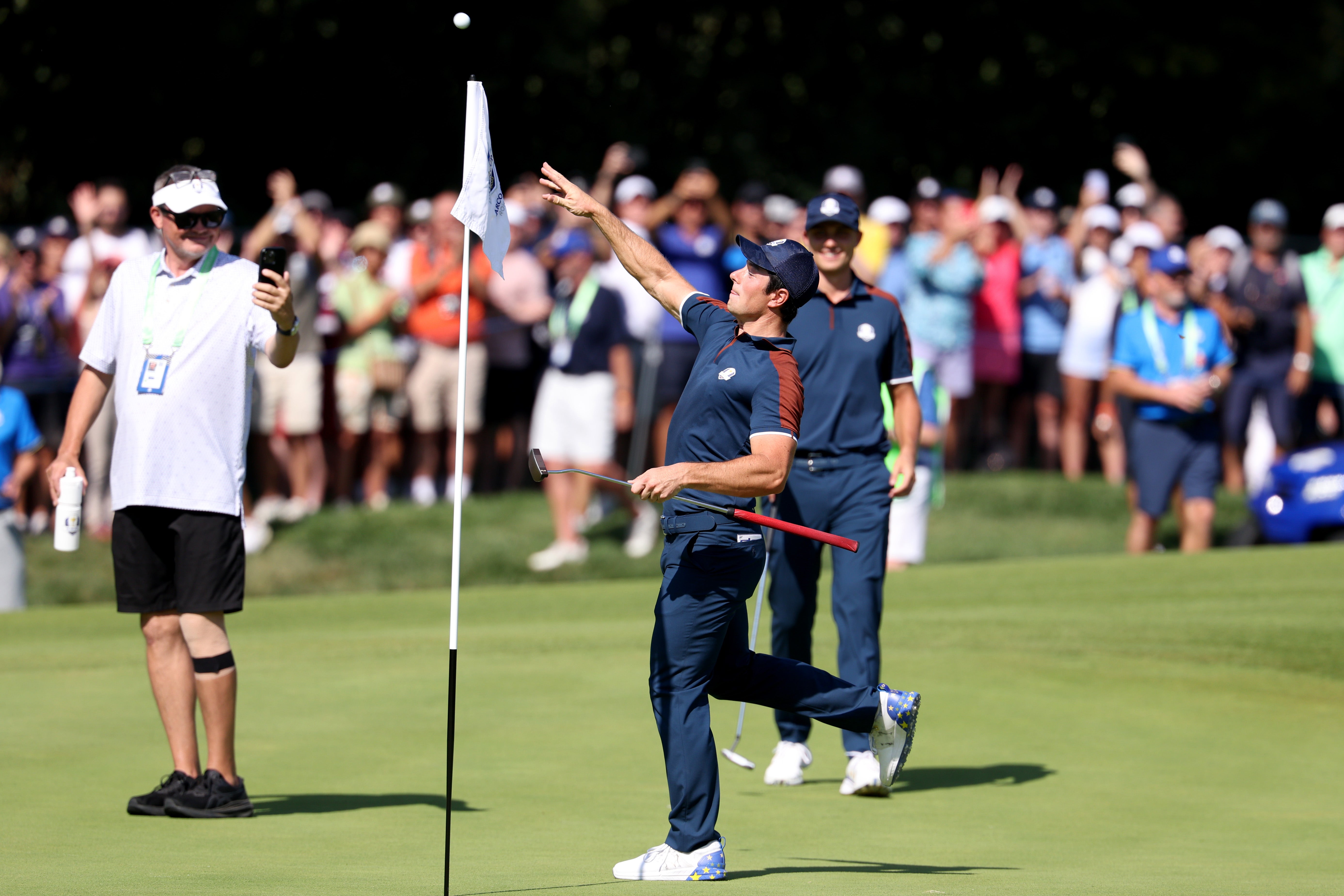 Hovland throws his ball to the crowd after fishing it from the hole