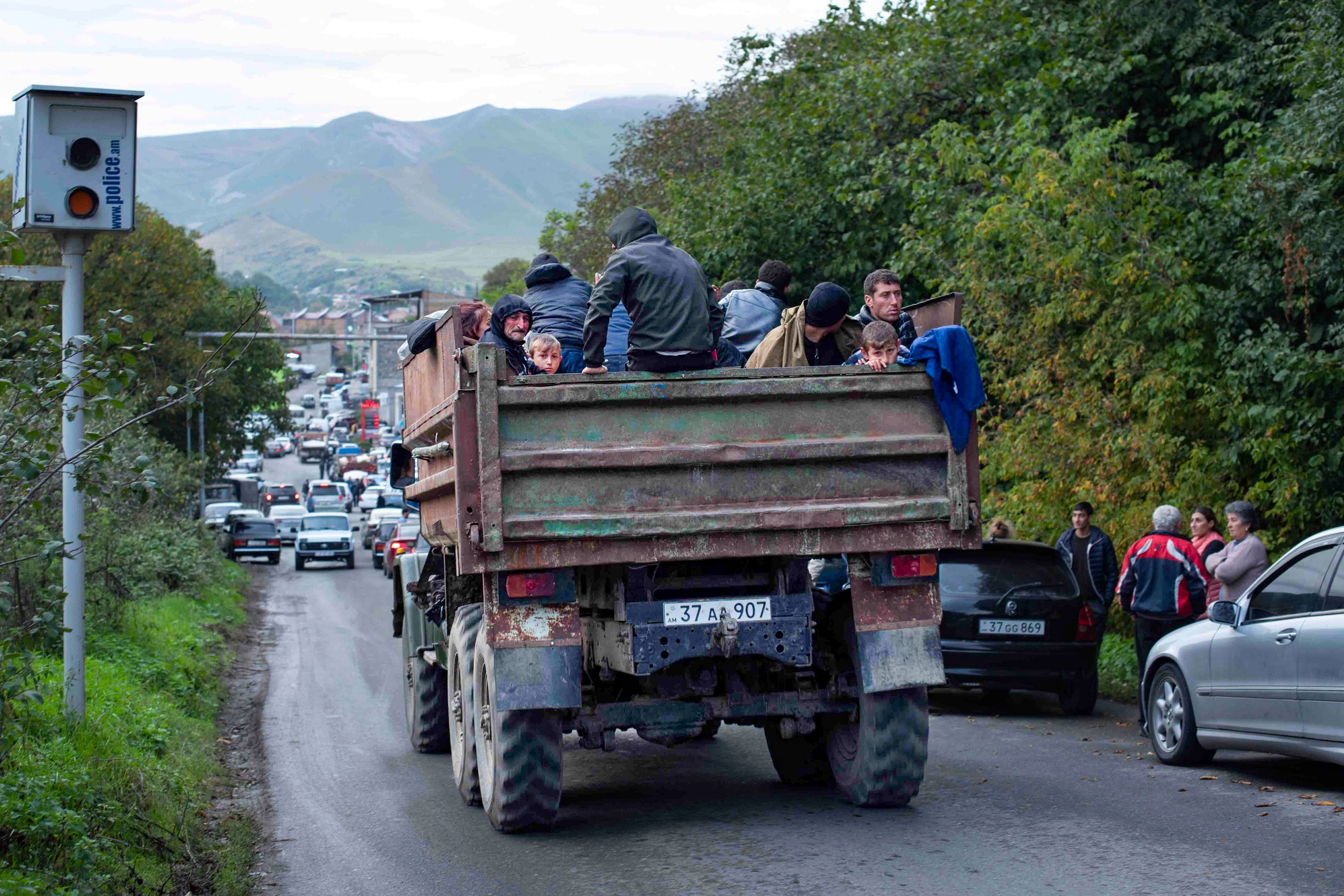 Ethnic Armenians fleeing Nagorno-Karabakh travel in the bed of a dump truck to Goris