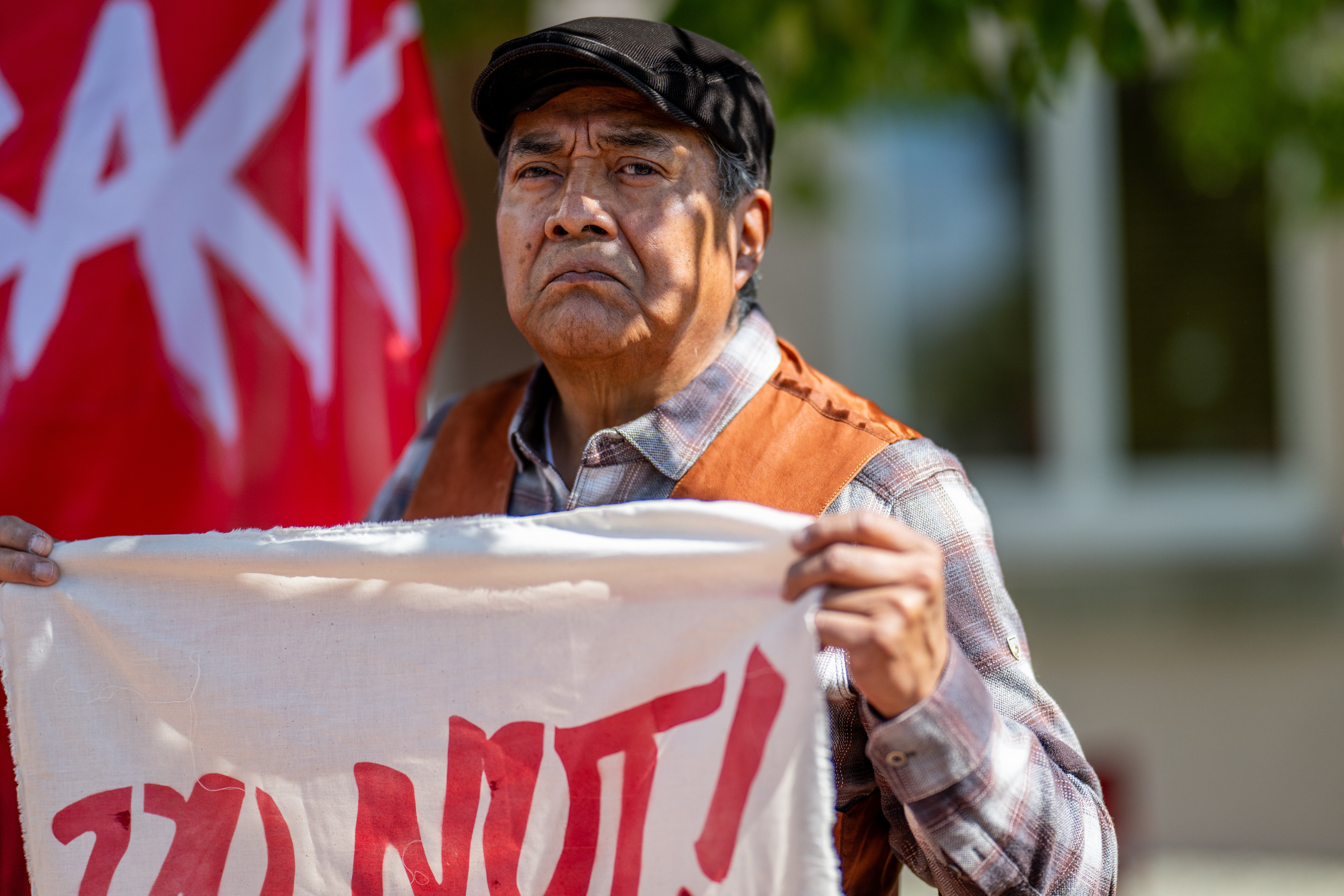 A person stands in protest against the reinstallation of a 16th-century New Mexico conquistador statue at the Rio Arriba County building on 28 September 2023