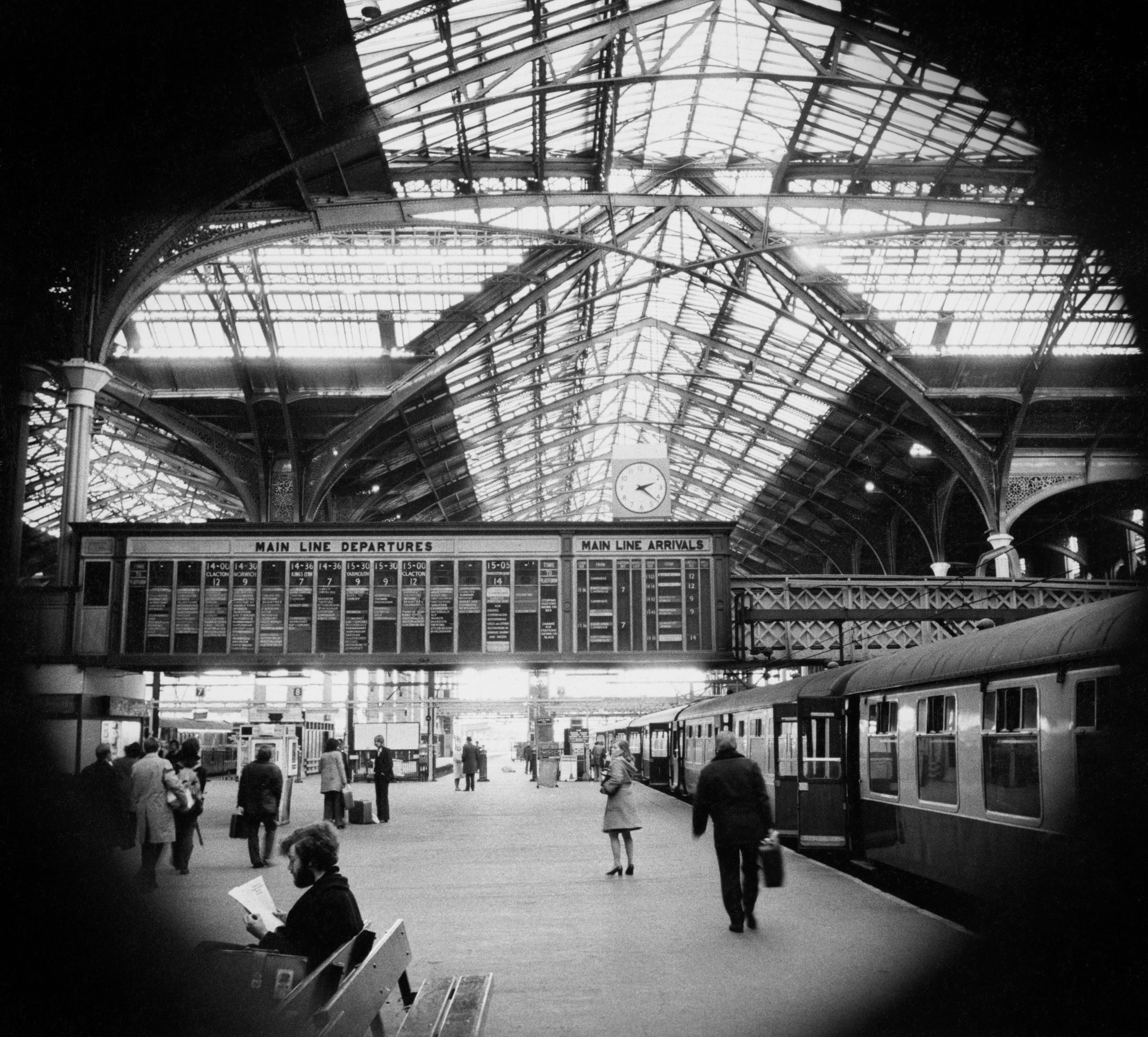 Rail passengers pass along a platform at Liverpool Street station in London, circa 1975