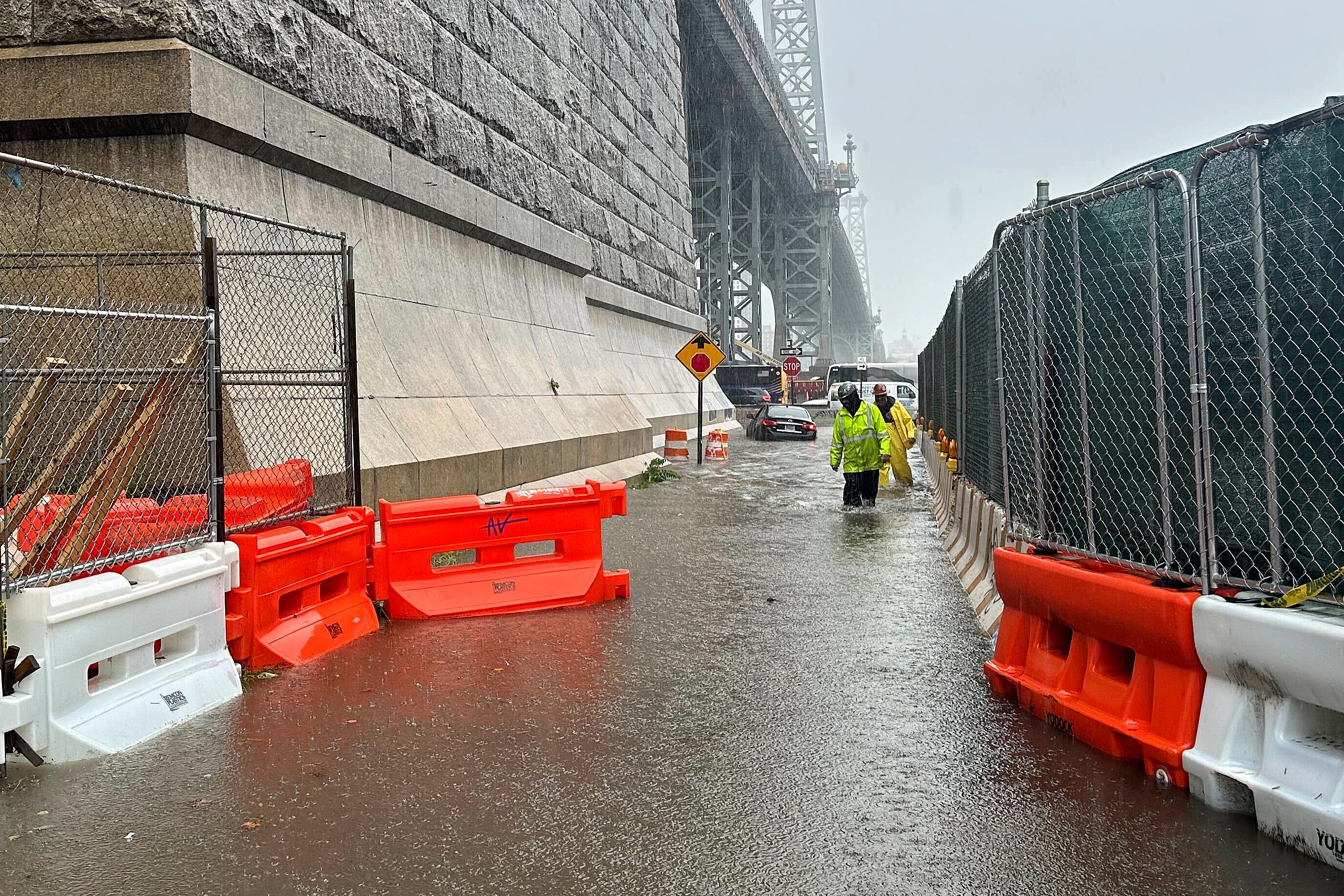 First responders wade through flood waters at the base of the Williamsburg Bridge on September 29 in New York