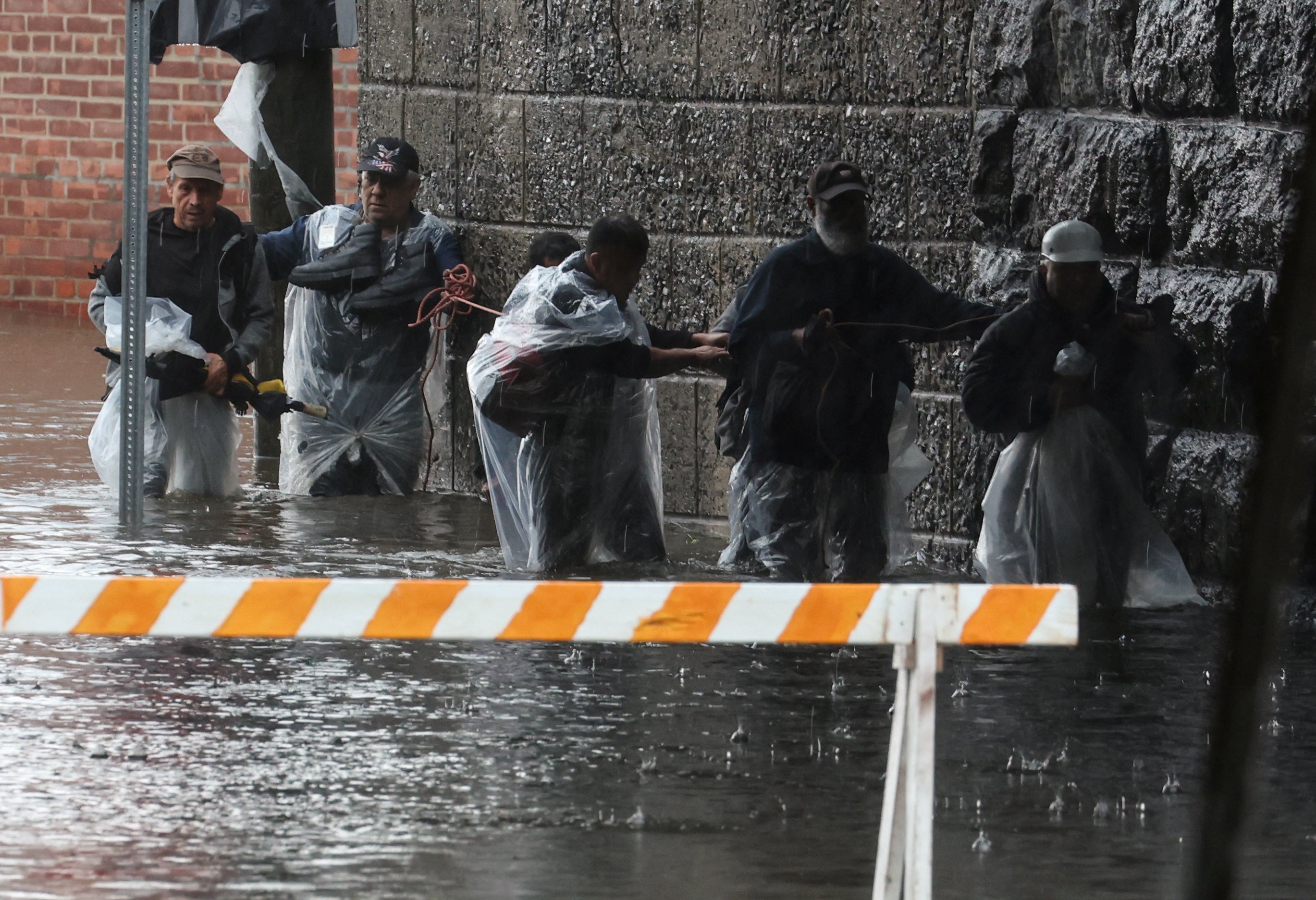 Residents escape rising floodwaters during a heavy rain storm in the New York City suburb of Mamaroneck in Westchester County, New York