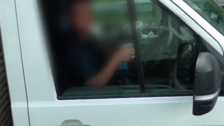 Truck driver takes both hands off steering wheel to drink cup of tea on M6