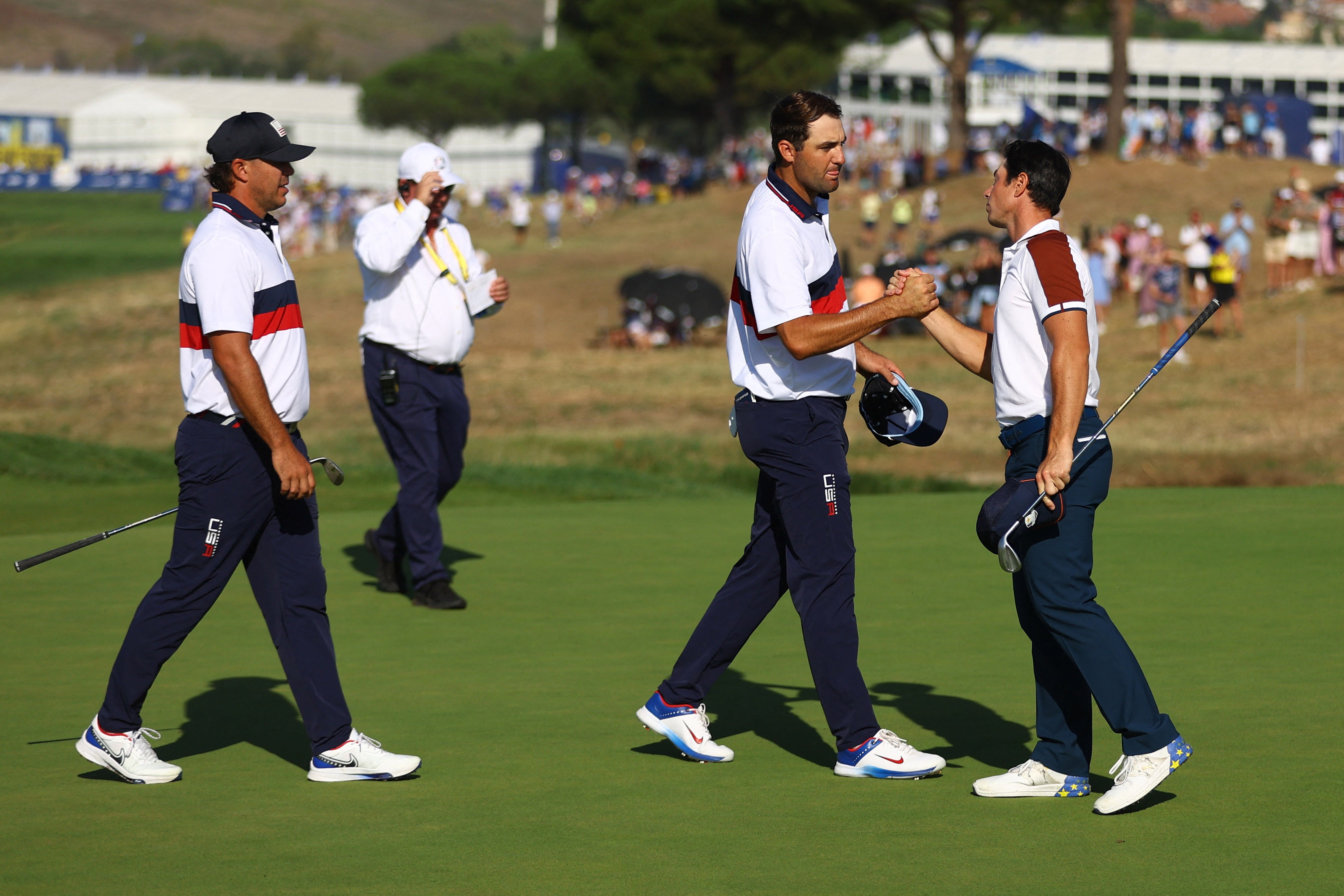 Viktor Hovland shakes hands with Scottie Scheffler as Brooks Koepka looks on